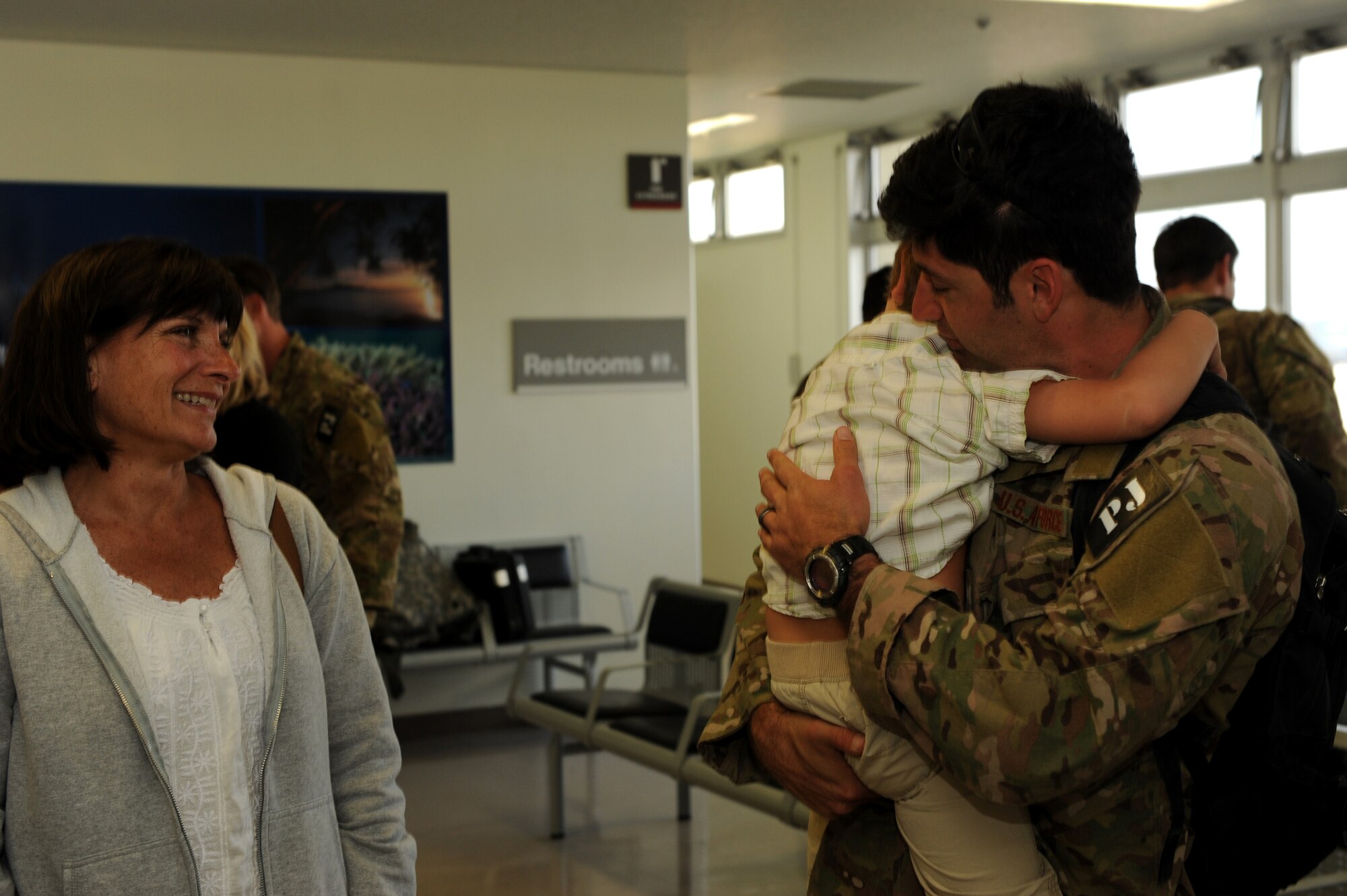 A pararescueman from the 31st Rescue Squadron embraces his son at the 733rd Air Mobility Squadron Passenger Terminal on Kadena Air Base, Japan, March 10, 2014. The 31st RQS trains, equips and employs combat-ready pararescue specialists. The pararescuemen are experts in medical care and small-unit tactics providing survivor contact, treatment and extraction during combat rescue operations in hostile or denied territory. (U.S. Air Force photo by Airman 1st Class Hailey R. Staker)