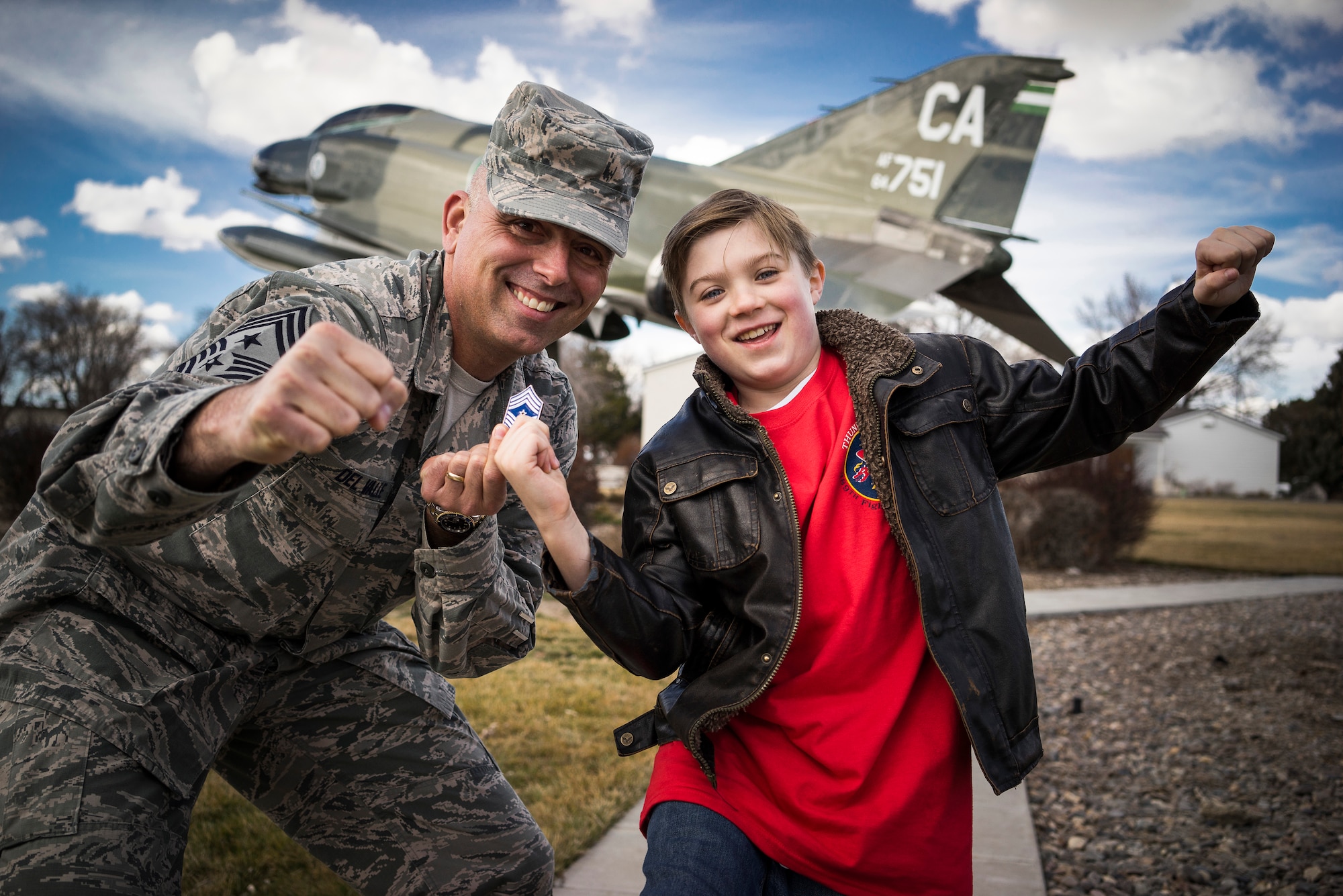 U.S. Air Force Chief Master Sgt. Alex Del Valle, 366th Fighter Wing command chief, poses for a photo with William Ciluaga, also known as "Idaho William," in front of an F-4 Phantom II static display at Mountain Home Air Force Base, Idaho, March 7, 2014. Ciluaga learned about how retired Maj. Gen. Frederick "Boots" Blesse came up with the idea to attach a 20-millimeter Gatling gun to the bottom of the F-4 during the Vietnam War. This increased their kill rate against enemy MiG fighters, thus giving the 366th Tactical Fighter Wing, predecessor to the 366th FW, the moniker "the Gunfighters." (U.S. Air Force photo by Tech. Sgt. Samuel Morse/RELEASED)