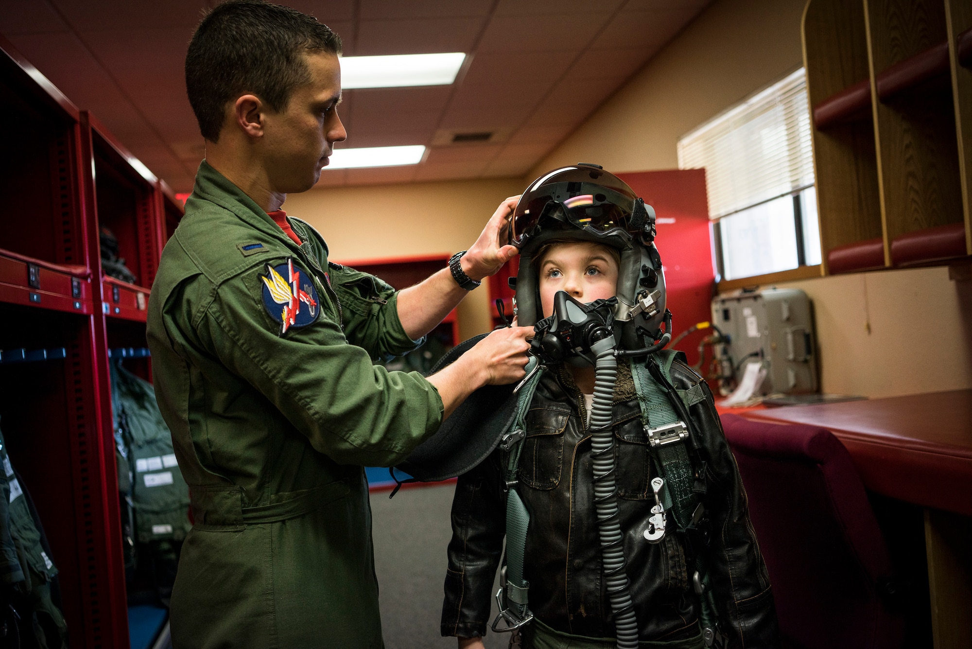 U.S. Air Force 1st Lt. Andrew Morton, 389th Fighter Squadron pilot, fits 9-year-old William Ciluaga with flight equipment at Mountain Home Air Force Base, Idaho, March 7, 2014. Ciluaga, also known as "Idaho William," visited the base to learn about its mission as well as create a video and journal entry with the help of his mom, Jessica Butterfield, about the experience. (U.S. Air Force photo by Tech. Sgt. Samuel Morse/RELEASED)