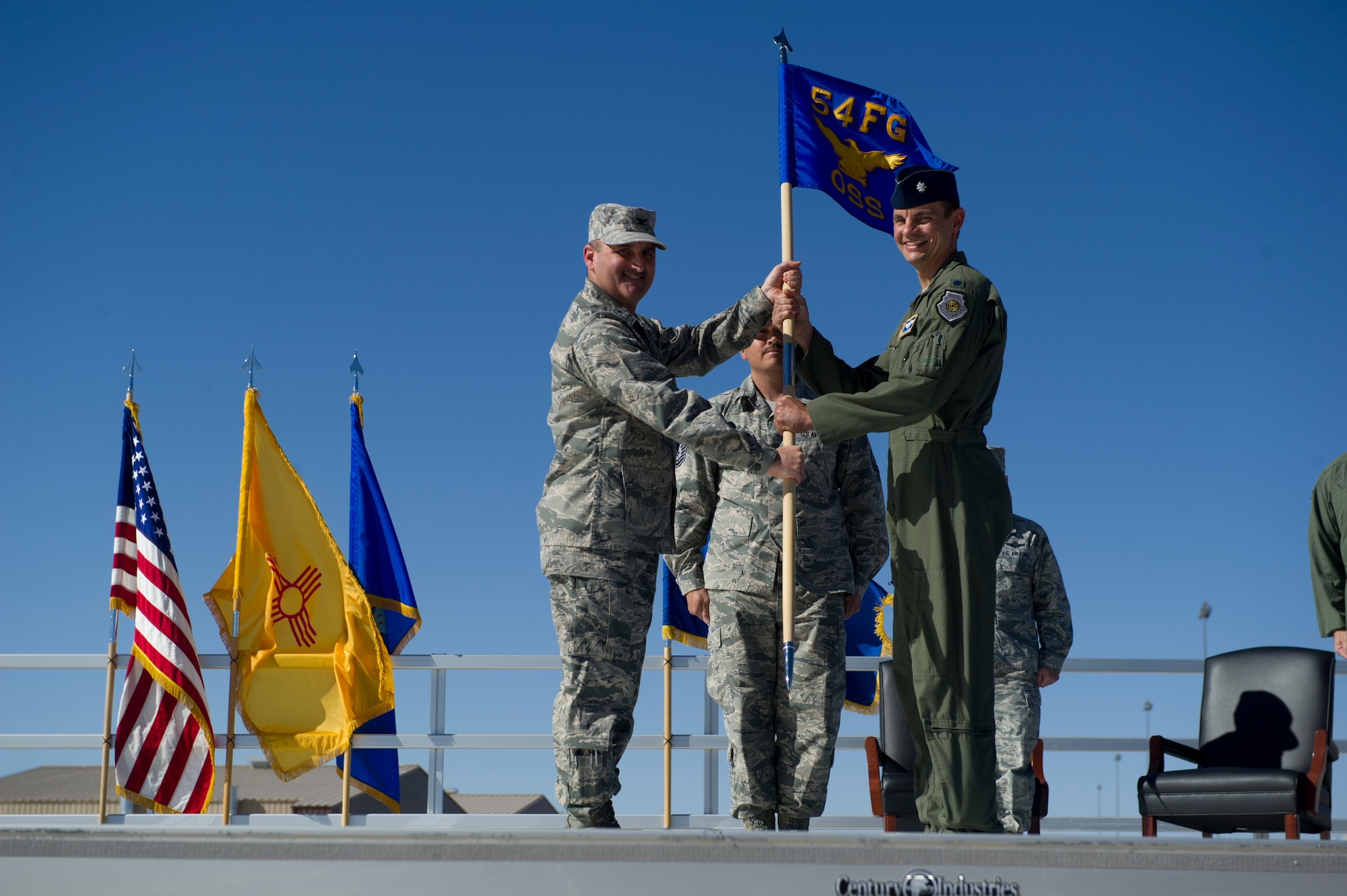 Col. Rodney Petithomme, 54th Fighter Group commander, passes the guidon of the 54th Operations Support Squadron to Lt. Col. Marshall Chalverus during the 54th Fighter Group activation ceremony at Holloman Air Force Base, N.M., March 11. The 54th Fighter Group, a tenant unit at Holloman, is a detachment the 56th Fighter Wing at Luke Air Force Base, Ariz., and will ultimately operate two F-16 Fighting Falcon aircraft training squadrons. The 54th Fighter Group plus three squadrons were activated at the ceremony: the 311th Fighter Squadron, the 54th Operations Support Squadron and the 54th Aircraft Maintenance Squadron. (U.S. Air Force photo by Airman 1st Class Chase A. Cannon/Released)