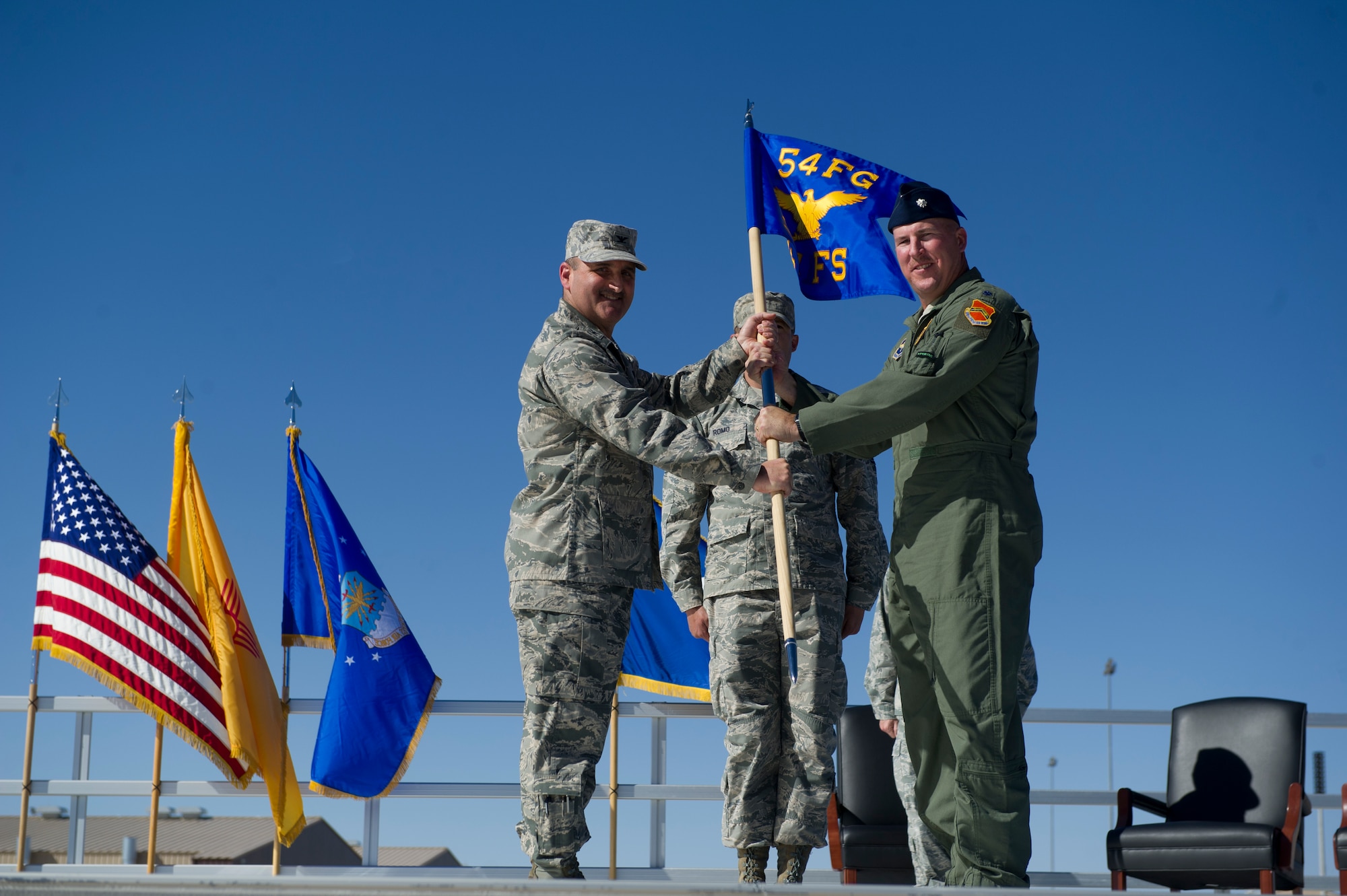 Col. Rodney Petithomme, 54th Fighter Group commander, passes the guidon of the 311th Fighter Squadron to Lt. Col. Scott Frederick during the 54th Fighter Group activation ceremony at Holloman Air Force Base, N.M., March 11. The 54th Fighter Group, a tenant unit at Holloman, is a detachment the 56th Fighter Wing at Luke Air Force Base, Ariz., and will ultimately operate two F-16 Fighting Falcon aircraft training squadrons. The 54th Fighter Group plus three squadrons were activated at the ceremony: the 311th Fighter Squadron, the 54th Operations Support Squadron and the 54th Aircraft Maintenance Squadron. (U.S. Air Force photo by Airman 1st Class Chase A. Cannon/Released)