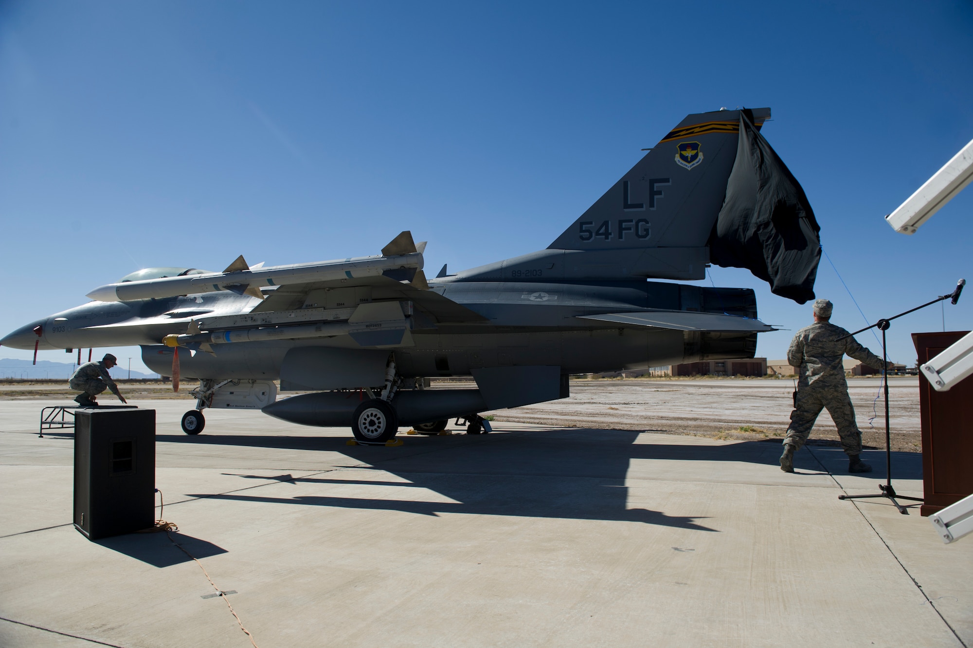 An F-16 Fighting Falcon donning the 54th Fighter Group tail flash is unveiled for the first time during the 54th Fighter Group activation ceremony at Holloman Air Force Base, N.M., March 11. The 54th Fighter Group, a tenant unit at Holloman, is a detachment the 56th Fighter Wing at Luke Air Force Base, Ariz., and will ultimately operate two F-16 Fighting Falcon aircraft training squadrons. The 54th Fighter Group plus three squadrons were activated at the ceremony: the 311th Fighter Squadron, the 54th Operations Support Squadron and the 54th Aircraft Maintenance Squadron. (U.S. Air Force photo by Airman 1st Class Chase A. Cannon/Released)
