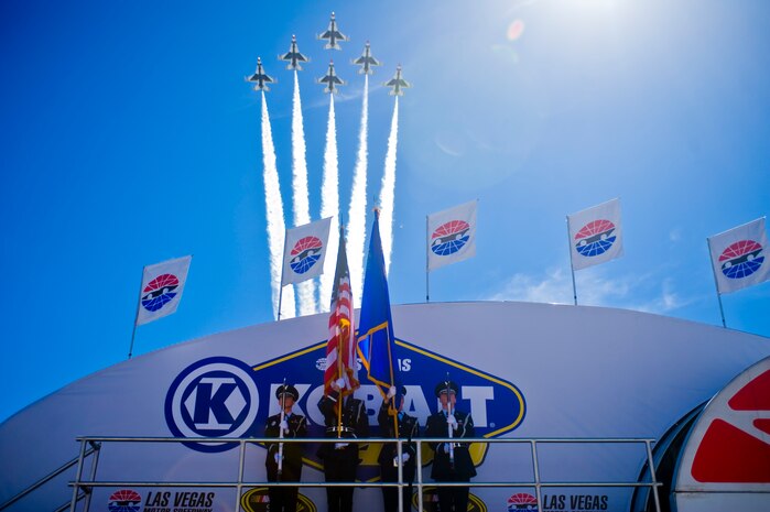 The Nellis Air Force Base Honor Guard present the colors while the U.S. Air Force Air Demonstration Squadron, Thunderbirds, perform a fly over during the opening ceremony of the Kobalt 400 NASCAR race March 9, 2014, at the Las Vegas Motor Speedway in Las Vegas. The Nellis AFB Honor Guard performs approximately 1,100 details annually and the Thunderbirds perform air shows throughout the year leading up to their last performance at Nellis AFB. (U.S. Air Force photo by Airman 1st Class Jake Carter)