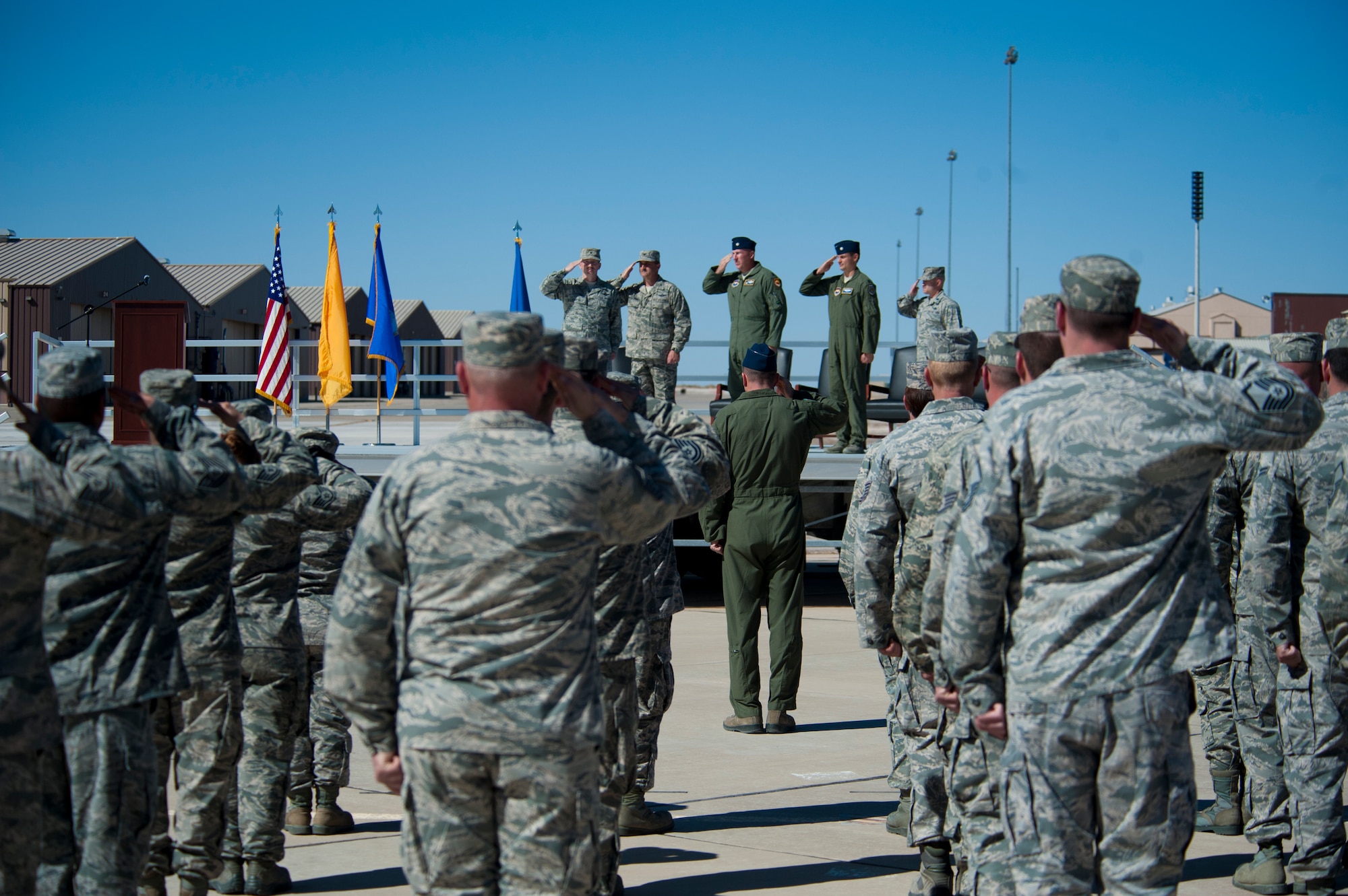 The official party and airmen in formation salute during the singing of the national anthem at Holloman Air Force Base, N.M., March 11. The 54th Fighter Group, a tenant unit at Holloman, is a detachment the 56th Fighter Wing at Luke Air Force Base, Ariz., and will ultimately operate two F-16 Fighting Falcon aircraft training squadrons. The 54th Fighter Group plus three squadrons were activated at the ceremony: the 311th Fighter Squadron, the 54th Operations Support Squadron and the 54th Aircraft Maintenance Squadron. (U.S. Air Force photo by Airman 1st Class Aaron Montoya / Released)