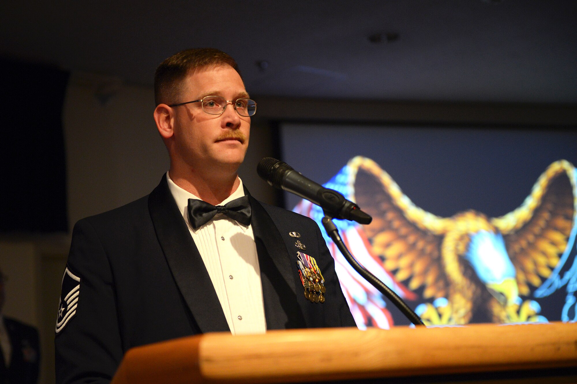 MSgt. Theodore Fest, 374th Security Forces Squadron flight chief of alpha flight, serves as a guest speaker at the 2013 annual awards at Yokota Air Base, Japan, Feb. 28, 2014. Fest explained the significance of the empty table used to represent airmen held as prisoners of war or missing in action. (U.S. Air Force photo by Airman 1st Class David Danford/Released)