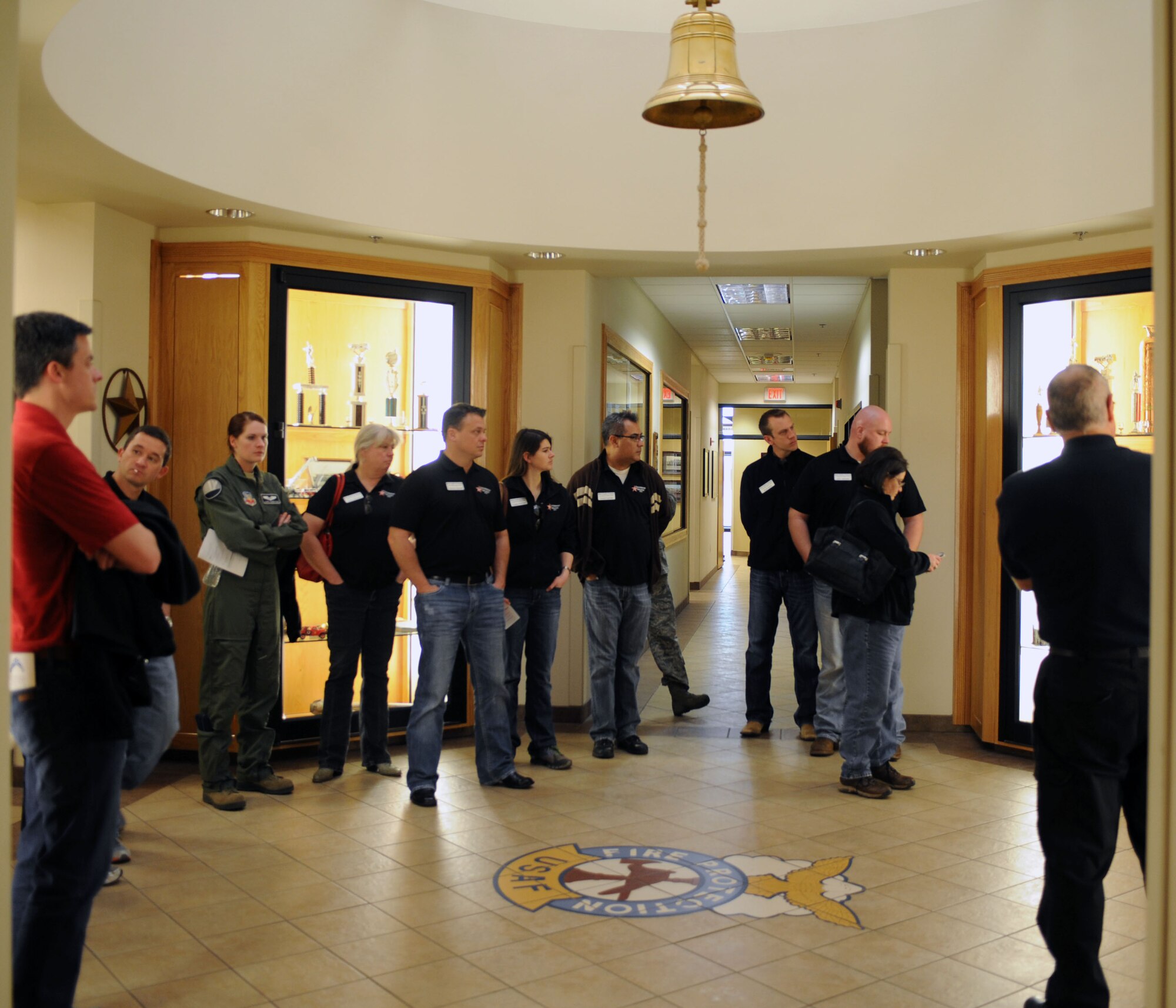 Leadership Abilene members tour the Dyess fire station March 7, 2014, at Dyess Air Force Base, Texas. During their tour, the group learned the significance of the Air Force firefighter badge and the bell that hangs above it. The badge displayed on the floor must never be stepped on and the bell is only rung when there is a fallen firefighter. (U.S. Air Force photo by Senior Airman Shannon Hall/Released)