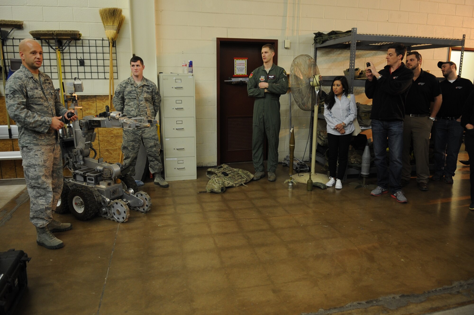U.S. Air Force Senior Airman John Fletcher, left, 7th Civil Engineer Squadron, briefs Leadership Abilene members about his job as an Explosive Ordinance Disposal member March 7, 2014, at Dyess Air Force Base, Texas. While touring the facility, the group had the opportunity to learn what EOD members do while deployed and how they assist local bomb squads in the surrounding communities. Leadership Abilene is a program intended to develop proficient leaders and is limited to 34 to 36 participants from different city organizations sponsored by the Abilene Chamber of Commerce. (U.S. Air Force photo by Senior Airman Shannon Hall/Released)