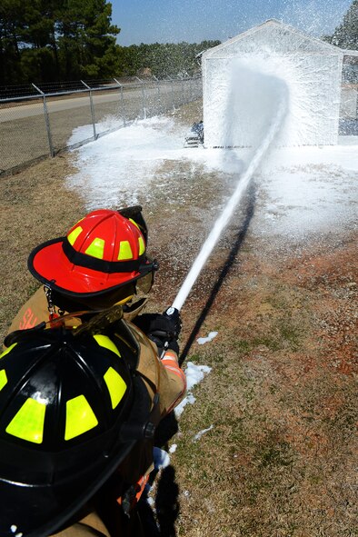 U.S. Air Force Staff Sgt. Patrick Bentley and Senior Airman Wesley Martin, 20th Civil Engineer Squadron firefighters, train with compressed air foam on a fixed structure at Shaw Air Force Base, S.C., March 10, 2014. 20th CES Airmen familiarized themselves with the new CAF a mixture of foam, water and air which cools the temperature of a structure down while also distinguishing flames. (U.S. Air Force photo by Airman 1st Class Jensen Stidham/Released)