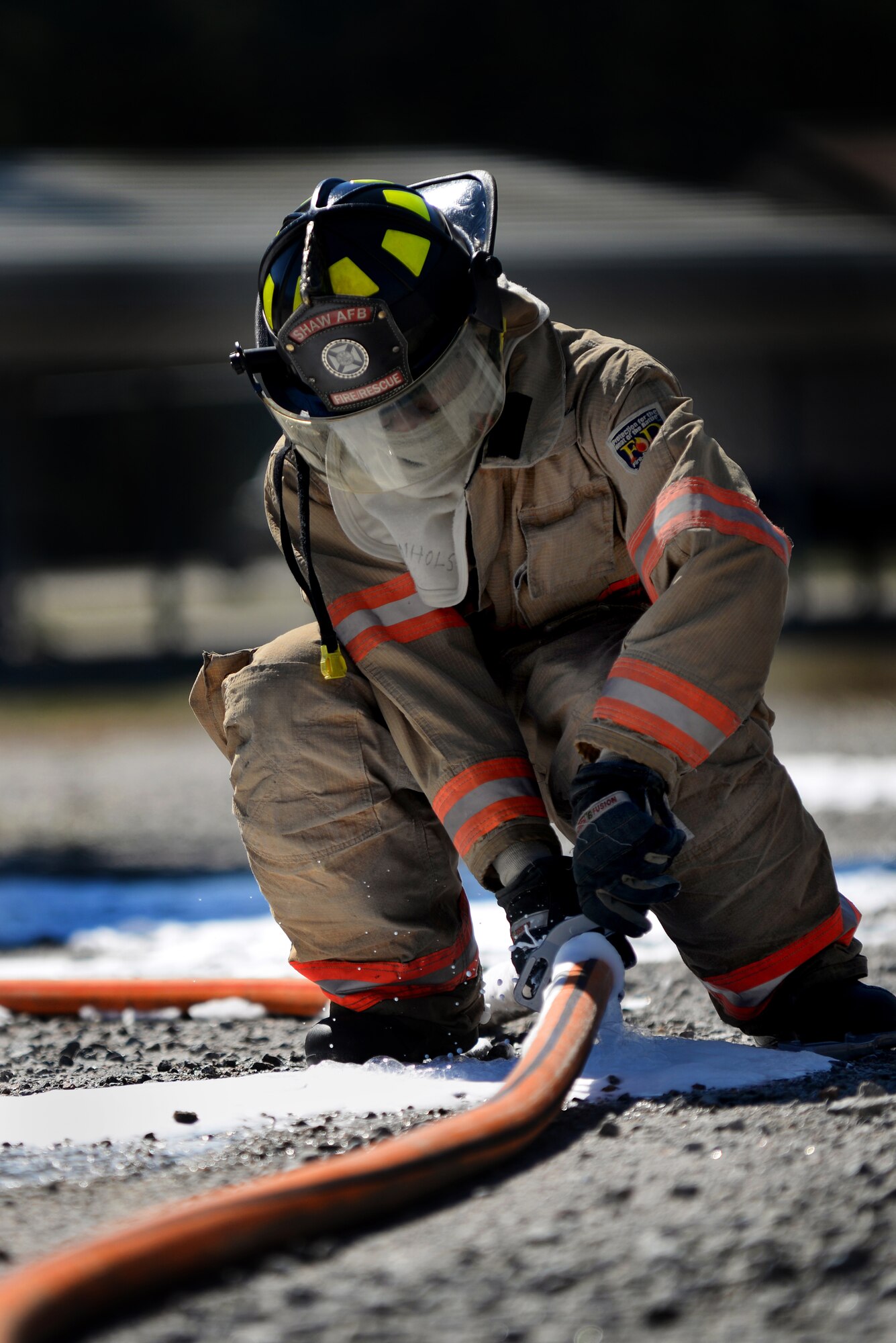 U.S. Air Force Airman 1st Class Jeffery Shinholster, 20th Civil Engineer Squadron firefighter, tightens the hose connector so that foam may flow freely, Shaw Air Force Base, S.C., March 10, 2014. The new compressed air foam system can make the water hose up to four times lighter. (U.S. Air Force photo by Airman 1st Class Michael A. Cossaboom/Released) 