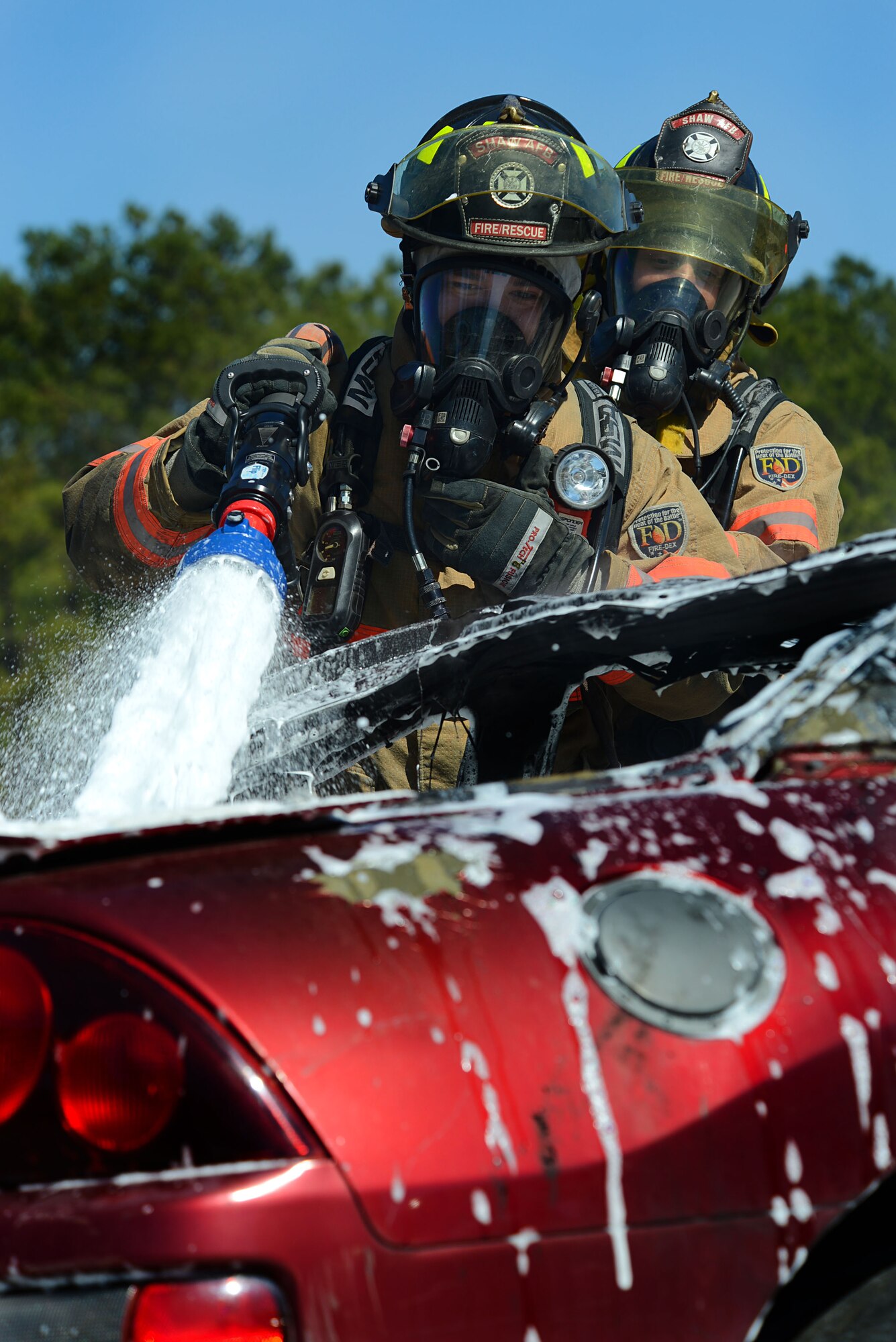 U.S Air Force Senior Airmen Brandon Young and Wesley Martin, 20th Civil Engineer Squadron firefighters, extinguish a controlled car fire using compressed air foam at Shaw Air Force Base, S.C., March 10, 2014. The 20th CES firefighters trained with a new CAF system, which makes the fire hose lighter and easier to use. (U.S. Air Force photo by Airman 1st Class Jensen Stidham/Released)