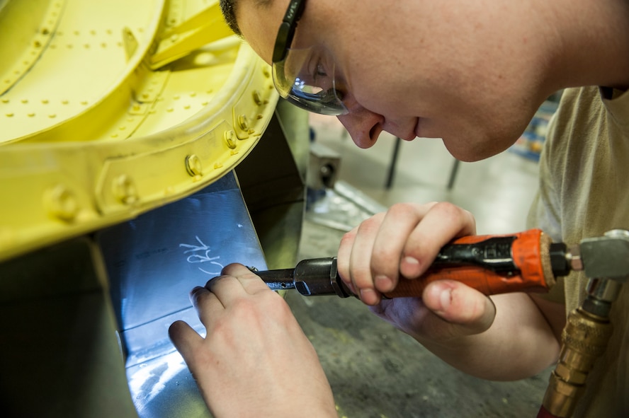 Staff Sgt. Ian Boivin, 5th Aircraft Maintenance Squadron sheet metal technician drills small holes into part of a B-52H Stratofortress at Minot Air Force Base, N.D., March 6, 2014. Boivin utilizes a wide range of tools to complete repairs including simple hand tools, air powered drills and pneumatic rivet squeezers. (U.S. Air Force photo/Senior Airman Stephanie Sauberan)