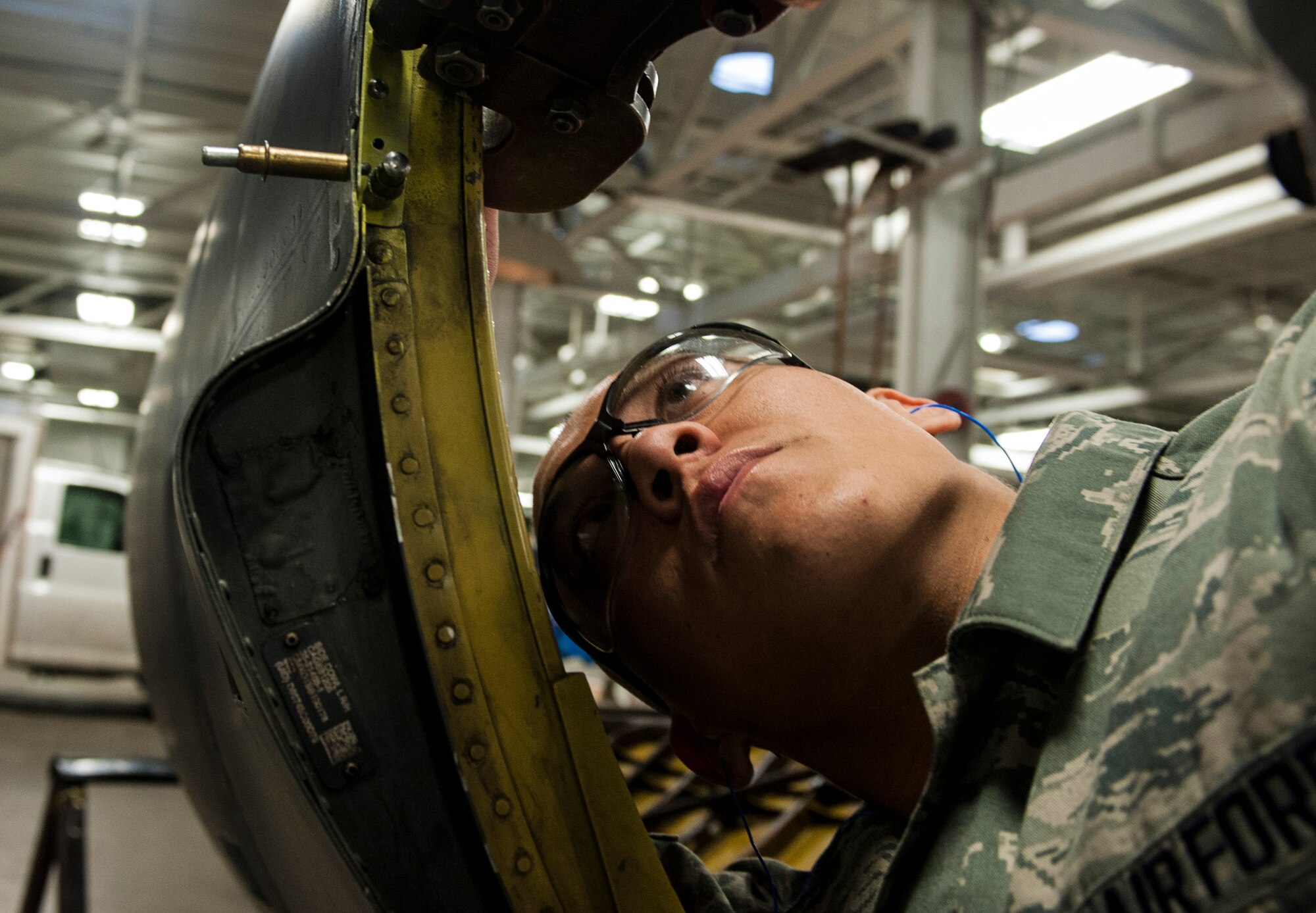 Airman 1st Class Aaron Manuel, 5th Aircraft Maintenance Squadron sheet metal technician uses a pneumatic rivet squeezer on part of a B-52H Stratofortress at Minot Air Force Base, N.D., March 6, 2014. Manuel checks the spacing and position of each rivet meticulously before securing them in place to ensure the safety and efficiency of the part. (U.S. Air Force photo/Senior Airman Stephanie Sauberan)