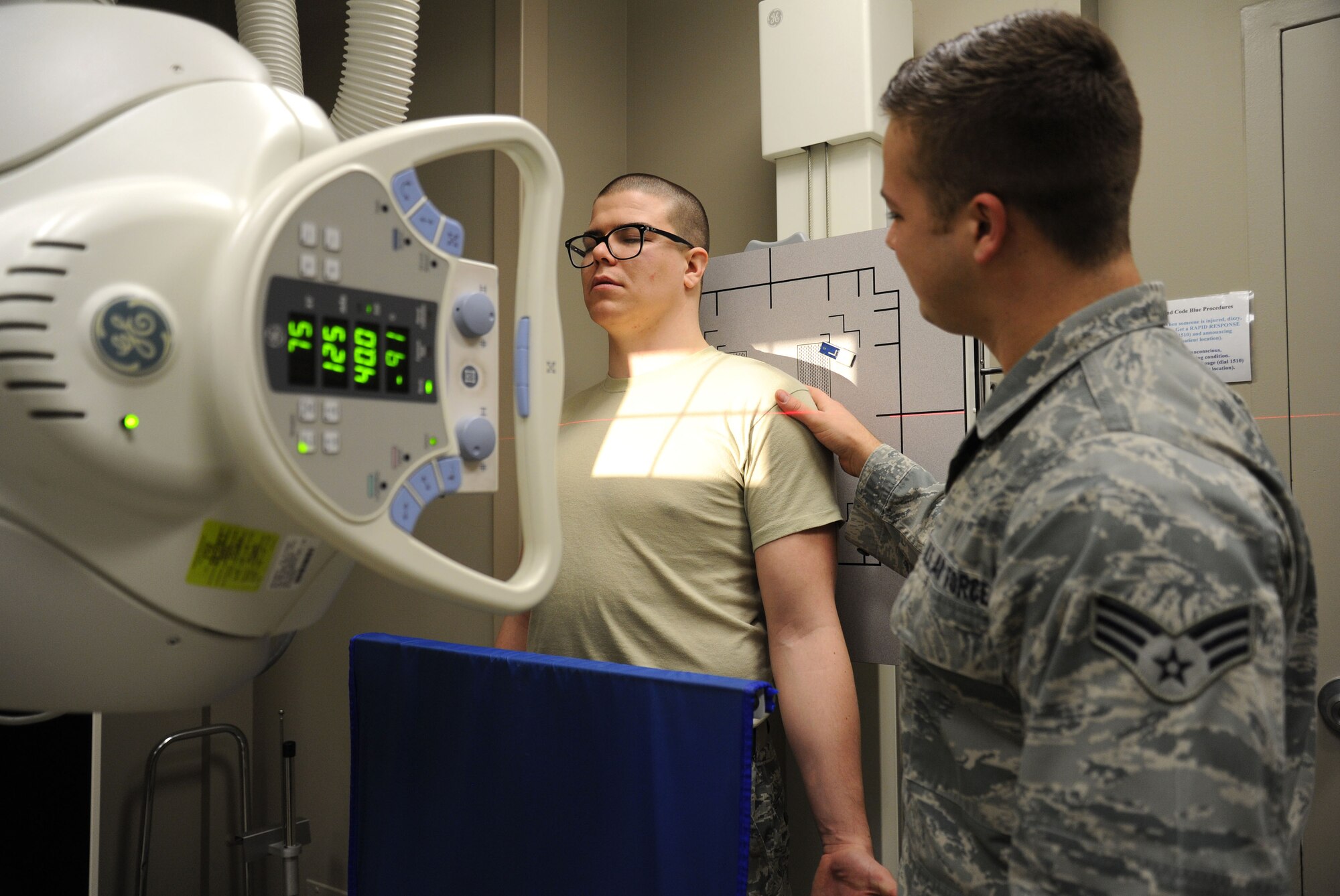 Senior Airman Timothy Carlson, 92nd Medical Support Squadron radiology technologist, positions a patient for standard shoulder view during an x-ray at Fairchild Air Force Base, Wash., March 10, 2014. Different positioning regarding the shoulder can determine injuries, fractures, possible bone disease, dislocations, malalignment, etc. (U.S. Air Force photo by Airman 1st Class Janelle Patiño/Released)