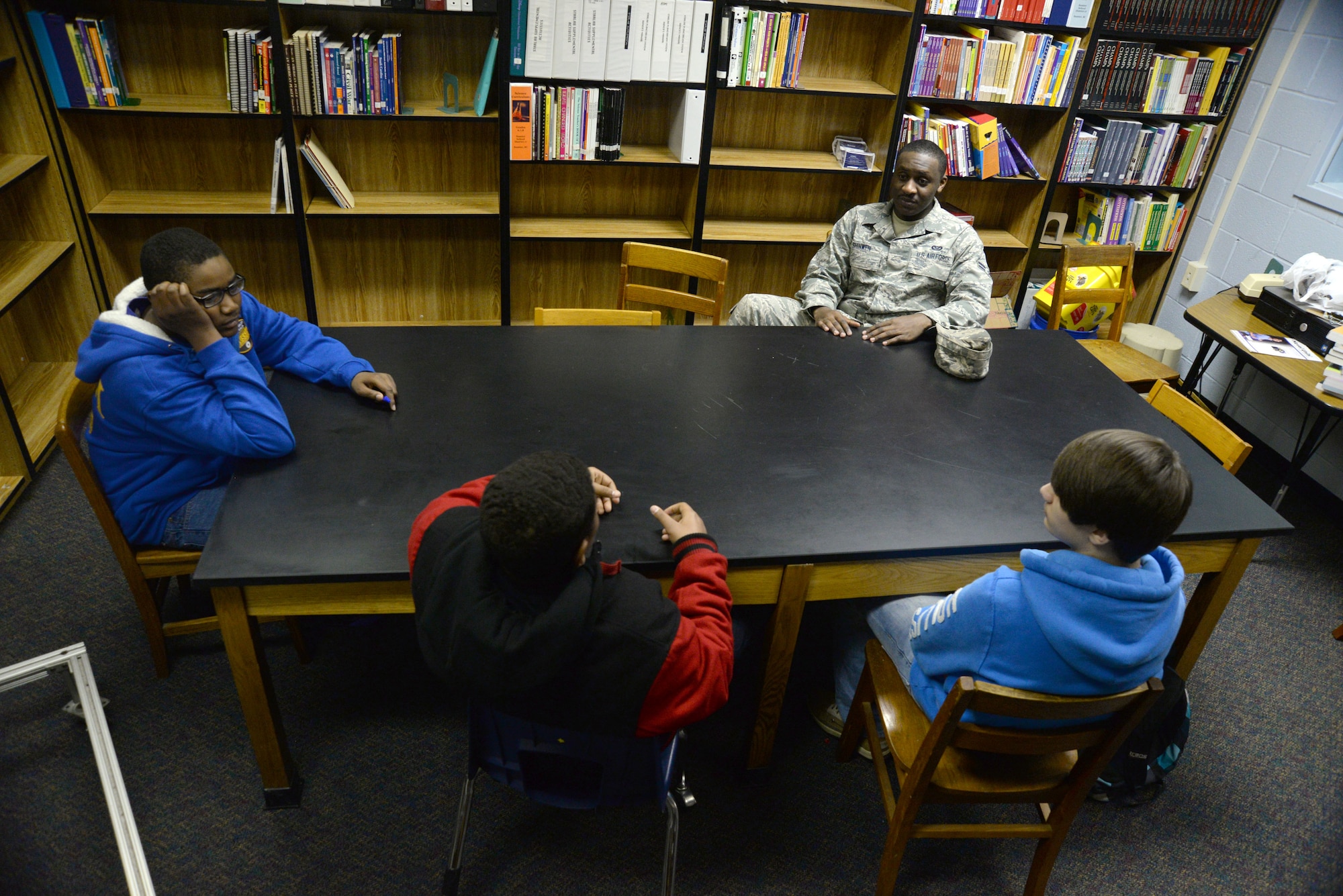 U.S. Air Force Airman 1st Class Valerie Shinwen, 20th Civil Engineer Squadron pest management specialist, talks with three students at Alice Drive Middle School as part of the Sumter School District Mentor Program, Sumter, S.C., March 4, 2014. Shinwen is one of more than 200 Airmen and Soldiers from Shaw Air Force Base who have committed to mentoring local students throughout the school year. (U.S. Air Force photo by Airman 1st Class Michael A. Cossaboom/Released)