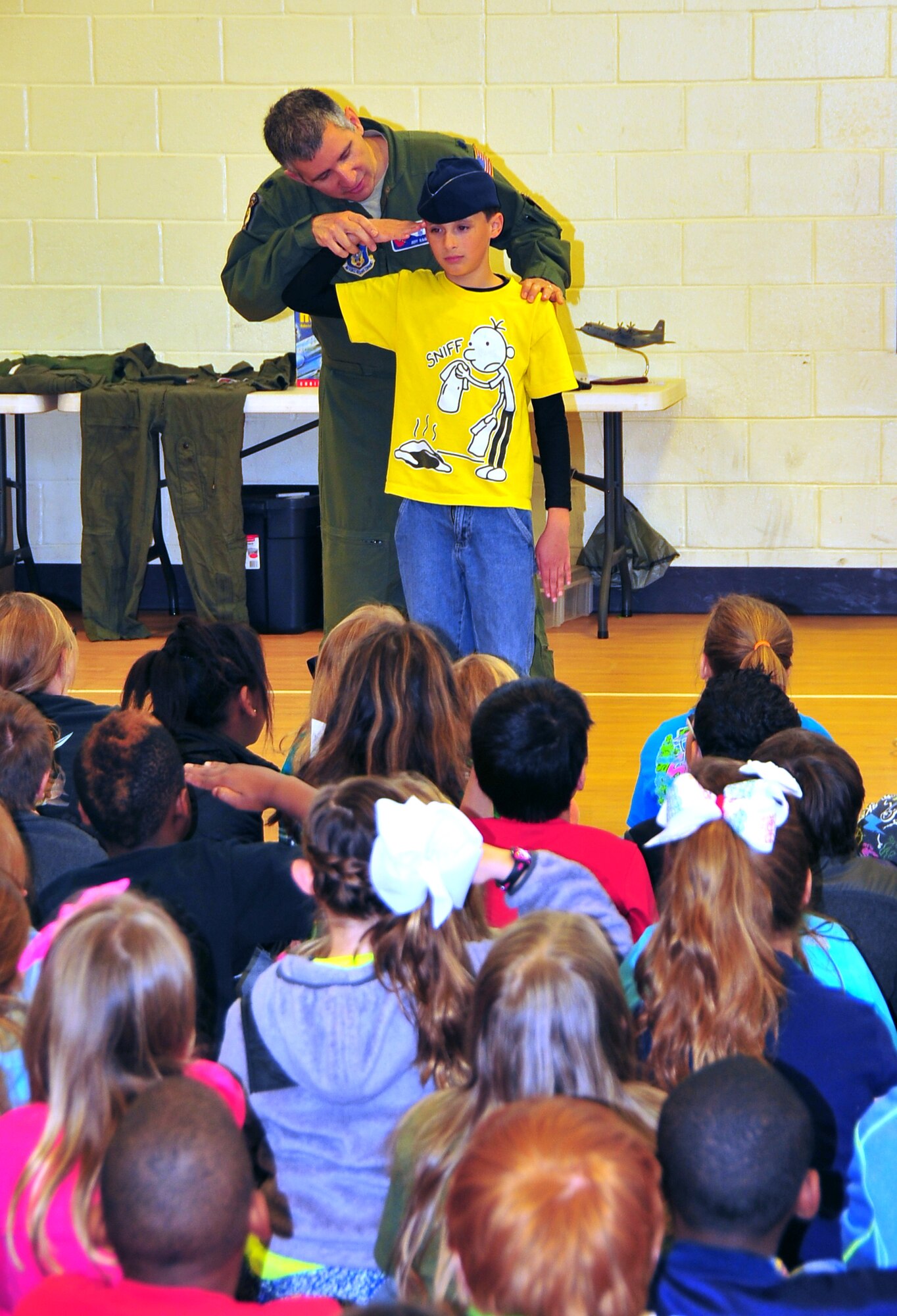 Lt. Col. Jeffrey Ragusa, 53rd Weather Reconnaissance Squadron pilot, shows a Harper McCaughan Middle School student how to salute March 7. Ragusa along with fellow squadron member and pilot Lt. Col. Shannon Hailes briefed 224 students at the Long Beach, Miss., school about the Hurricane Hunter mission. (U.S. Air Force photo/Maj. Marnee A.C. Losurdo)