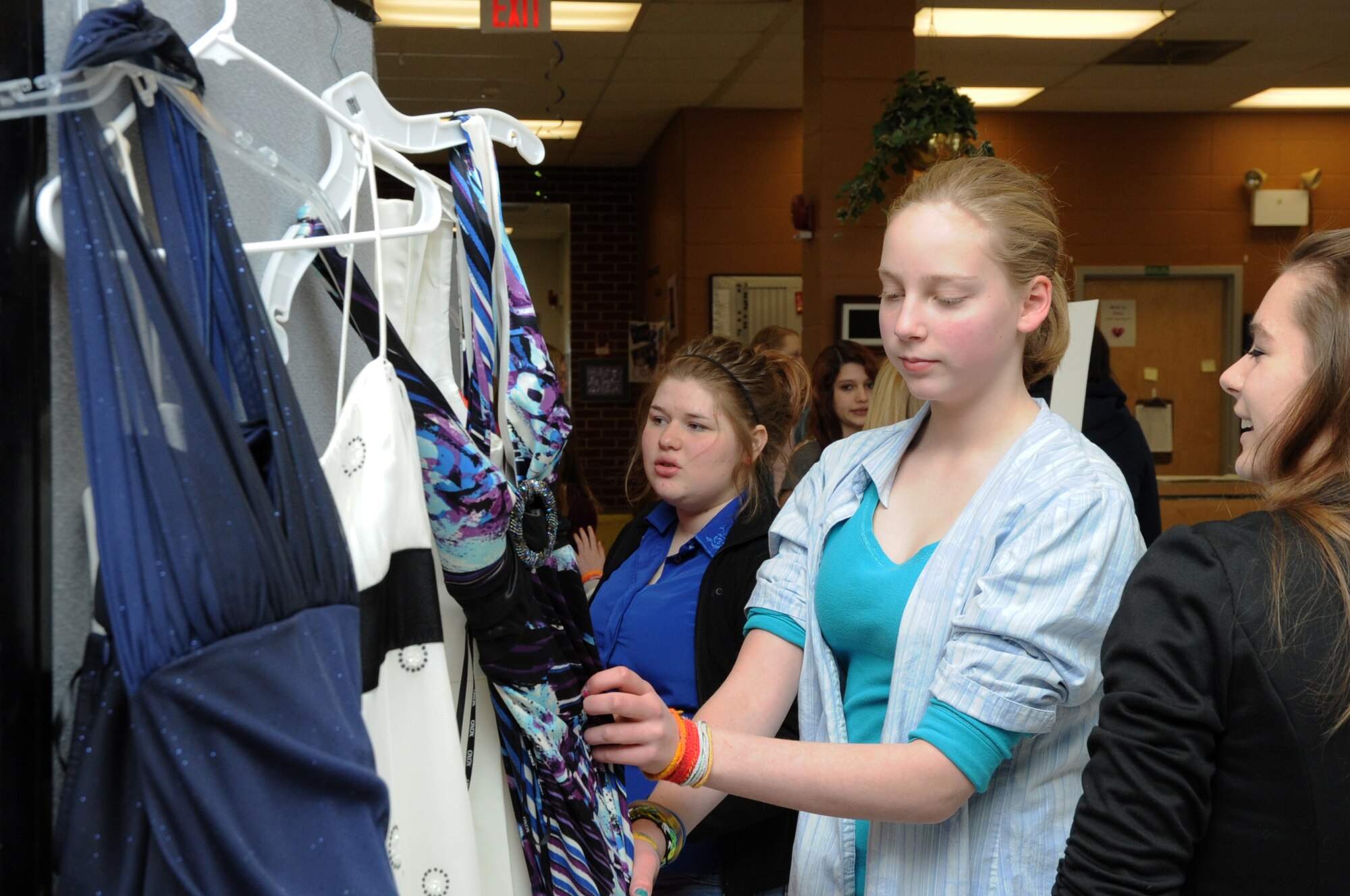 (From left) Siblings Elizabeth and Angelina Cerone and Cheyenne Kurtz browse donated dresses during the 319th Force Support Squadron Prom Prep Academy event at the Youth Center on Grand Forks Air Force Base, N.D., March 8, 2014. High school students from military families were invited to pick out a dress to keep for their school proms. (U.S. Air Force photo/Staff Sgt. David Dobrydney)