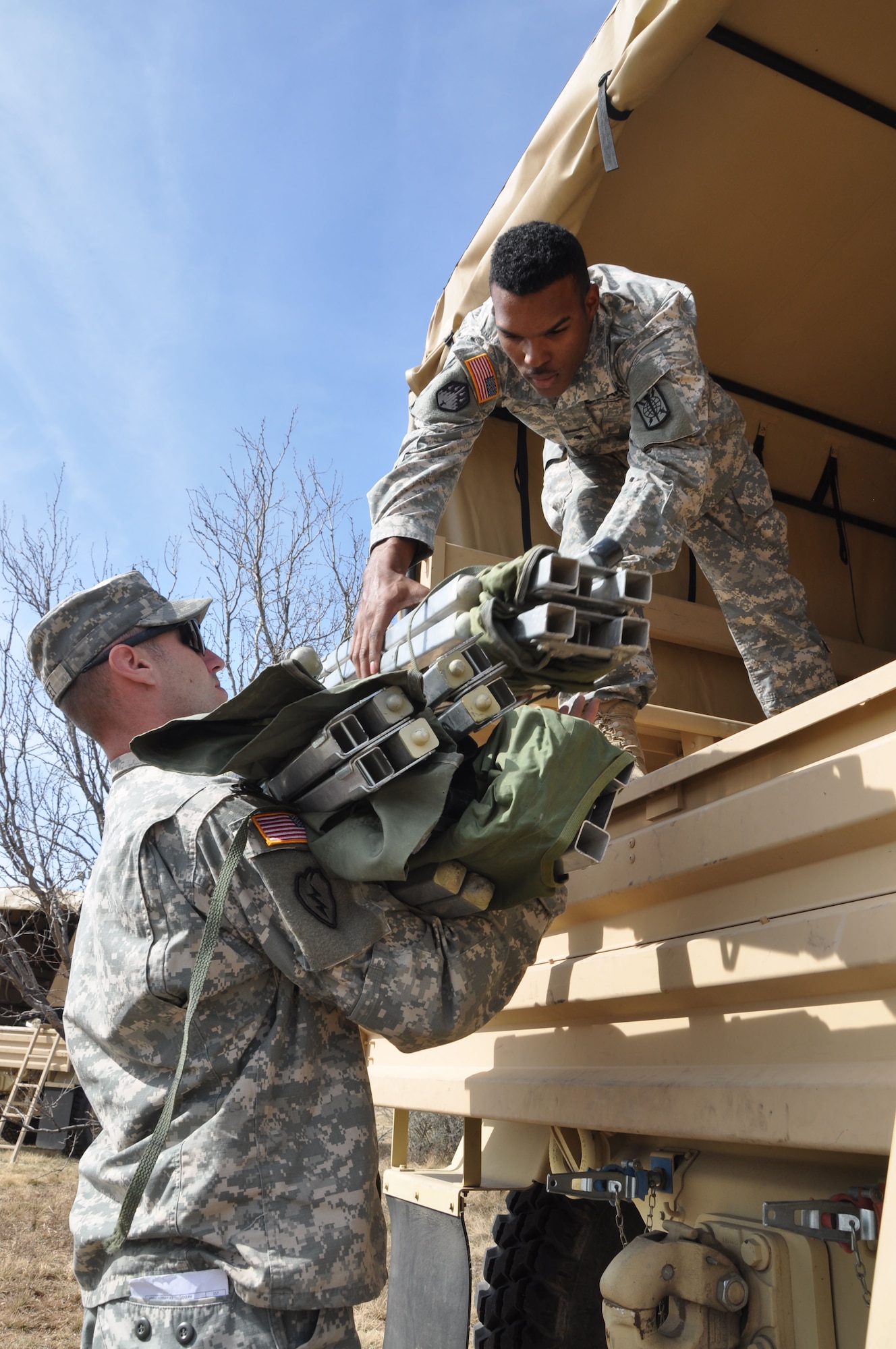 GOODFELLOW AIR FORCE BASE, Texas – A Soldier from the 15th Military Intelligence Aerial Exploitation Battalion takes cots off of a convoy vehicle here Feb. 24. The 15 MI BN (AE) came to Goodfellow Air Force Base to conduct a field training exercise to test several different intelligence systems on the training grounds here. (U.S. Air Force photo/ Airman 1st Class Breonna Veal)