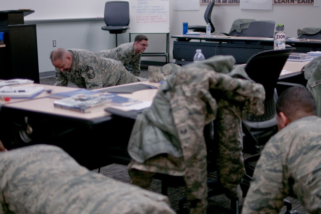 JOINT BASE ELMENDORF-RICHARDSON, Alaska -- Chief Master Sgt. Paul Verrier, chief of the 176 Maintenance Operations Flight, demonstrates "leading from the front" during a classroom session at the Enlisted Leadership Seminar 2014 here March 1, 2014. Seventy-five junior non-commissioned officers from the Alaska Air National Guard's 176 Wing gathered for a leadership conference organized by the Kulis Chief's Council. National Guard photo by Staff Sgt. N. Alicia Halla/ Released.