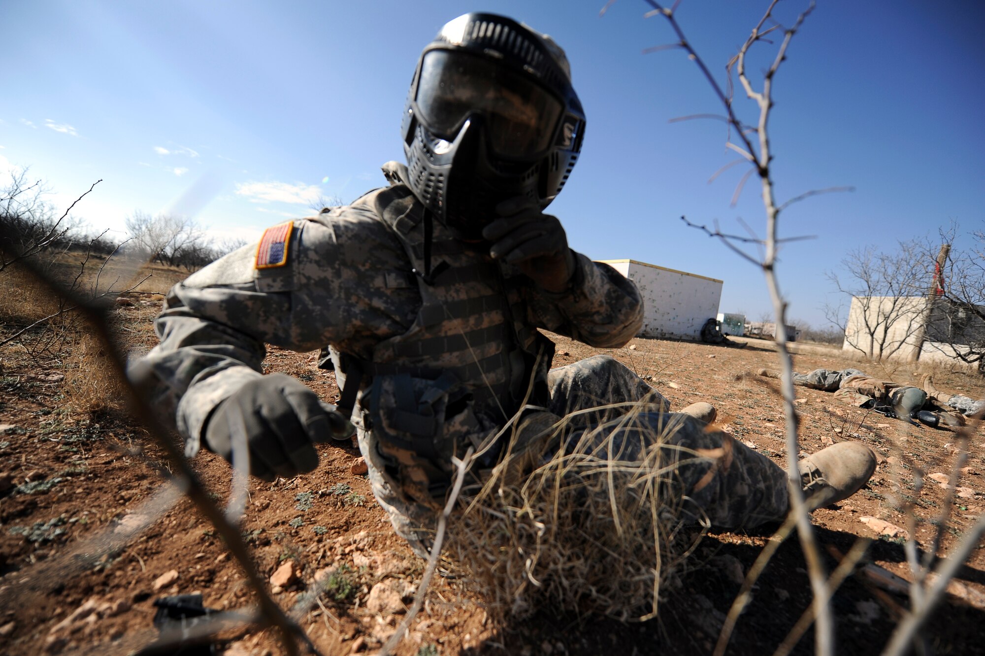 GOODFELLOW AIR FORCE BASE, Texas --A simulated wounded Soldier hits the ground as his whole team is immobilized by enemy fire during a paintball battle drill at the combat simulation course here Feb. 26.  Soldiers from the 15th Military Intelligence Aerial Exploitation Battalion came to Goodfellow for a field training exercise which included Soldiers stationed here with the 344th Military Intelligence Battalion. (U.S. Air Force photo/ Staff Sgt. Austin Knox)
