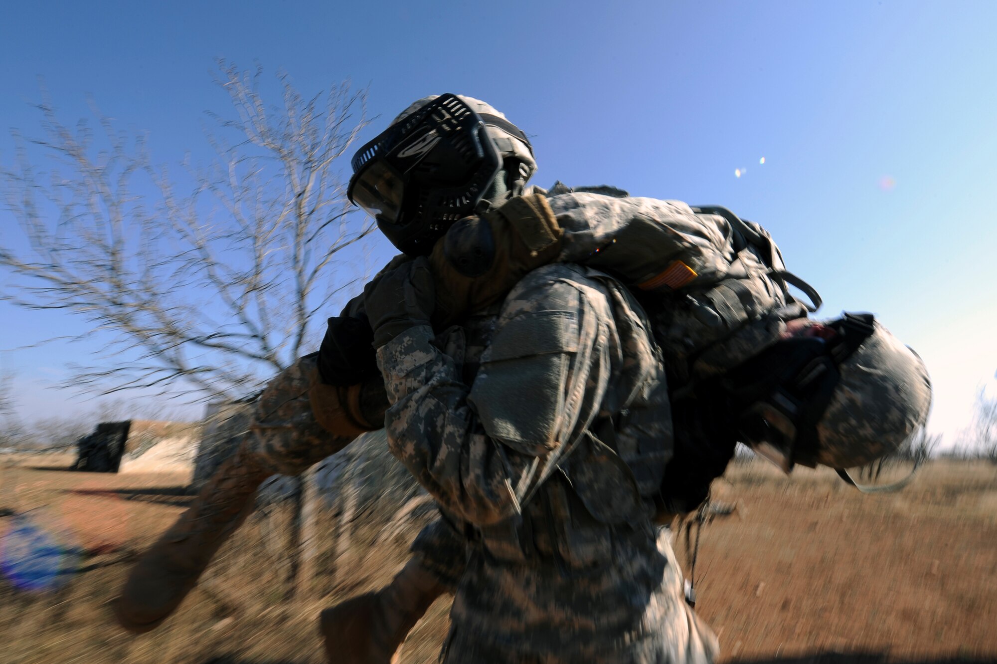 GOODFELLOW AIR FORCE BASE, Texas -- A Soldier from the 15th Military Intelligence Aerial Exploitation Battalion, Fort Hood, Texas, fireman-carries a simulated wounded Soldier from the 344th Military Intelligence Battalion during a battle drill at the combat simulation course here Feb. 26.  The 15th MI BN (AE) came to Goodfellow for a three-day field exercise to test their training in an unfamiliar environment.   (U.S. Air Force photo/ Staff Sgt. Austin Knox)