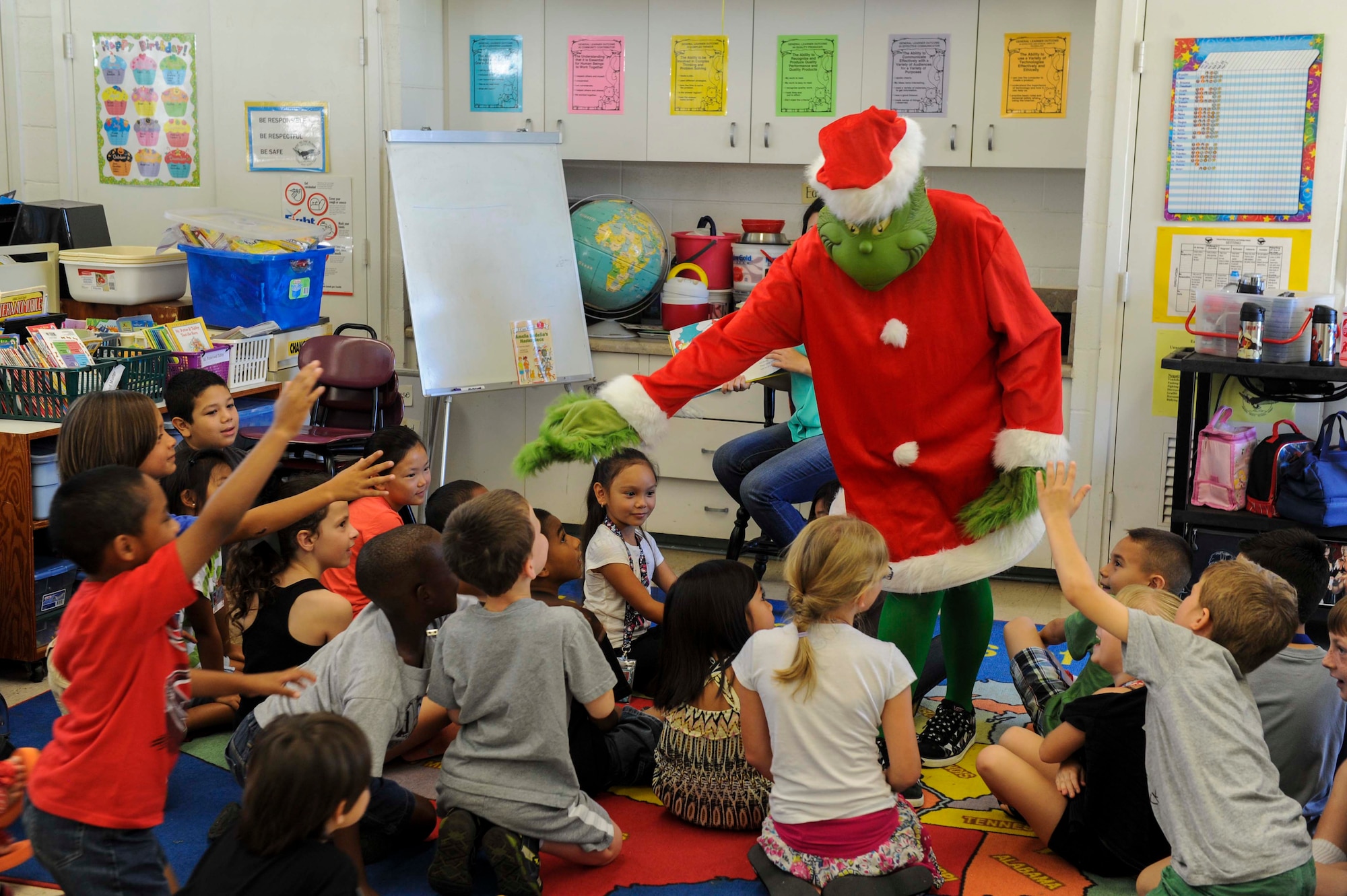 The Grinch shakes hands with second-grade students at Nimitz Elementary School in Honolulu, Hawaii, March 10, 2014, as part of Read Across Nimitz. A nod to the 17th Annual Read Across America Day, which was held March 3, Read Across Nimitz is a localized program hosted by Nimitz Elementary School to help build awareness of the importance of reading. In addition to celebrating the birthday of Dr. Seuss, both programs focus on motivating children and teens to read more through innovative events and storytelling. (U.S. Air Force photo/Tech. Sgt. Terri Paden)