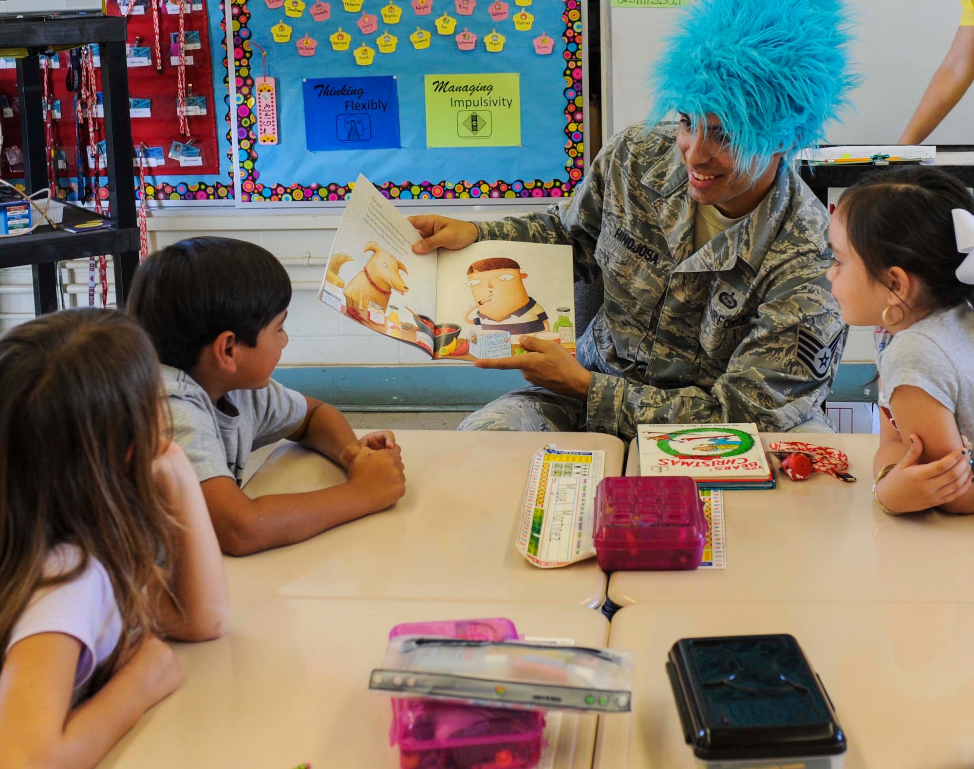 Staff Sgt. Joe Hinojosa, Pacific Command NCO, reads "Why Do Dragons Love Tacos" to second-grade students at Nimitz Elementary School in Honolulu, Hawaii, March 10, 2014, as part of Read Across Nimitz. Hinojosa joined other Airmen and members of the local community to take part in the program aimed at motivating children to read more through innovative events and storytelling. (U.S. Air Force photo/Tech. Sgt. Terri Paden)