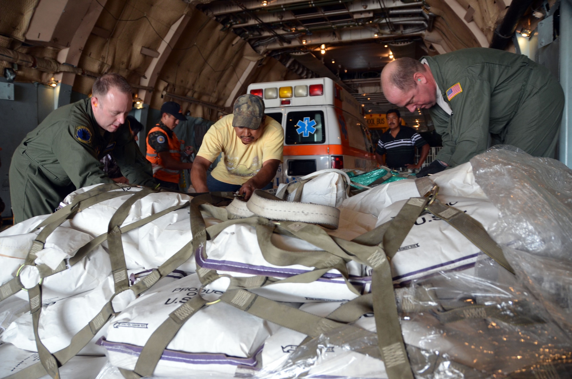 MSgt. Steven Duplessis, 439th Airlift Control Flight Loadmaster and SMSgt. John Sandova, 337th Airlift Squadron Loadmaster, work with volunteers in Guatemala to unload the pallets of corn March 9, 2014. A Westover C-5 and crew delivered 20 tons of humanitarian aid to Guatemala City, Guatemala. The aid included an ambulance, bus, two pallets of corn, and medical supplies. The corn will service thousands of Mayan Indian families who use the vegetable as their only staple to make tortillas. The ambulance will service 80,000 Mayan Indians as it will be the only one of its kind in the region. The school bus will facilitate transportation for 13,000 Mayan children for education purposes.

Missions like these are made possible by the Denton Amendment, which allows the Air Force to deliver donated humanitarian aid on a space-available basis. This particular mission was coordinated with the Mission of Love Foundation, a non-profit organization based in Austintown, Ohio. (U.S. Air Force photo/SSgt. Kelly Goonan)