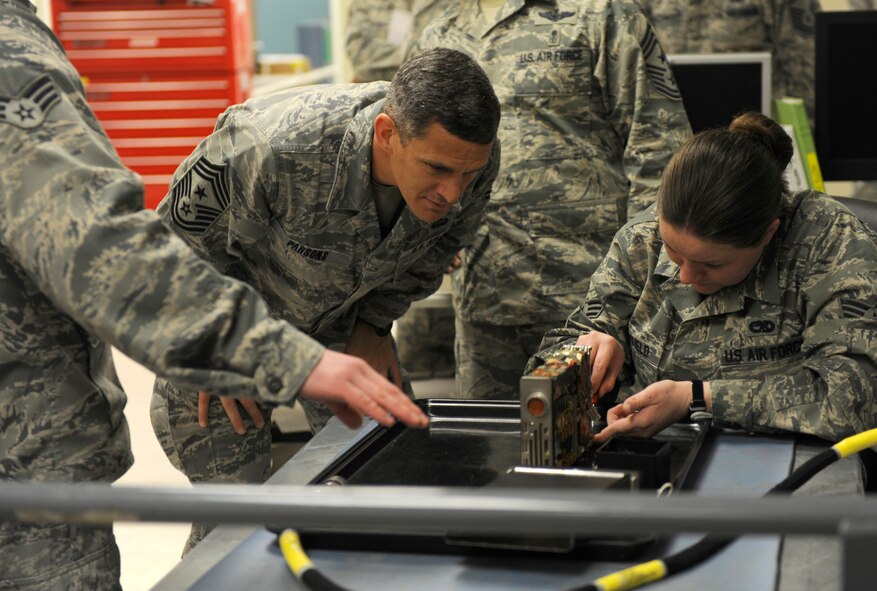 U.S. Air Force Chief Master Sgt. Richard Parsons, Air Combat Command command chief, observes as Senior Airman Katie Sheffield, 7th Maintenance Group, works on an aircraft’s avionics component March 5, 2014, at Dyess Air Force Base, Texas. Parsons interacted with several Airmen and let them know how important their job is in maintaining the Air Force’s air superiority. (U.S. Air Force photo by Airman 1st Class Alexander Guerrero/Released)