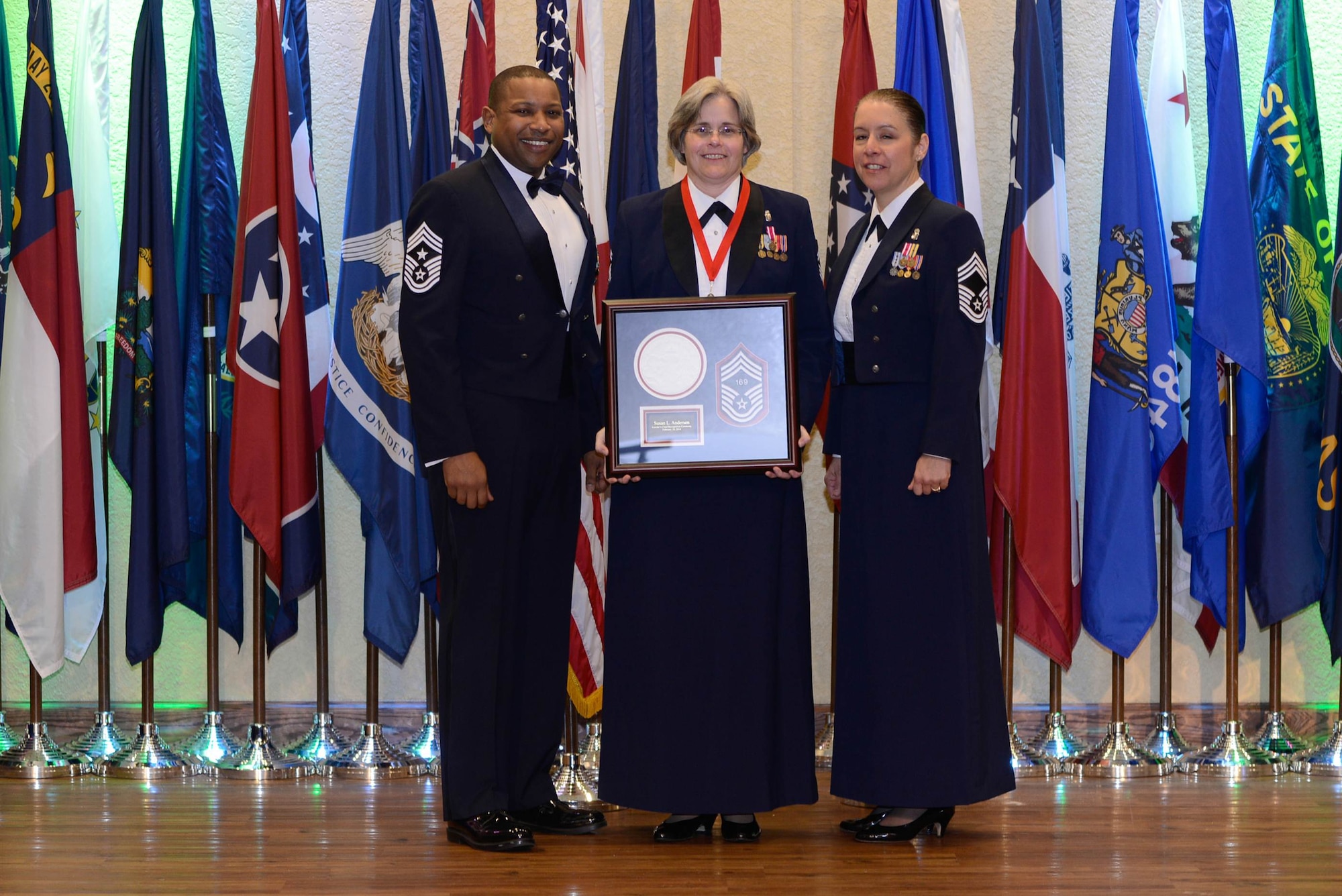 Senior Master Sgt. Susan Andersen, 81st Diagnostic and Therapeutics Squadron, receives her honoree gift which was presented by Chief Master Sgts. Farrell Thomas, 81st Training Wing command chief, and Paula Eischen, 81st MDTS and Keesler Chiefs Group president, during the Chiefs Recognition Ceremony Feb. 28, 2014, at the Bay Breeze Event Center, Keesler Air Force Base, Miss.  Keesler had four Airmen that were honored for attaining the rank of chief master sergeant.  (Courtesy photo by Airman 1st Class Andrew Achong)