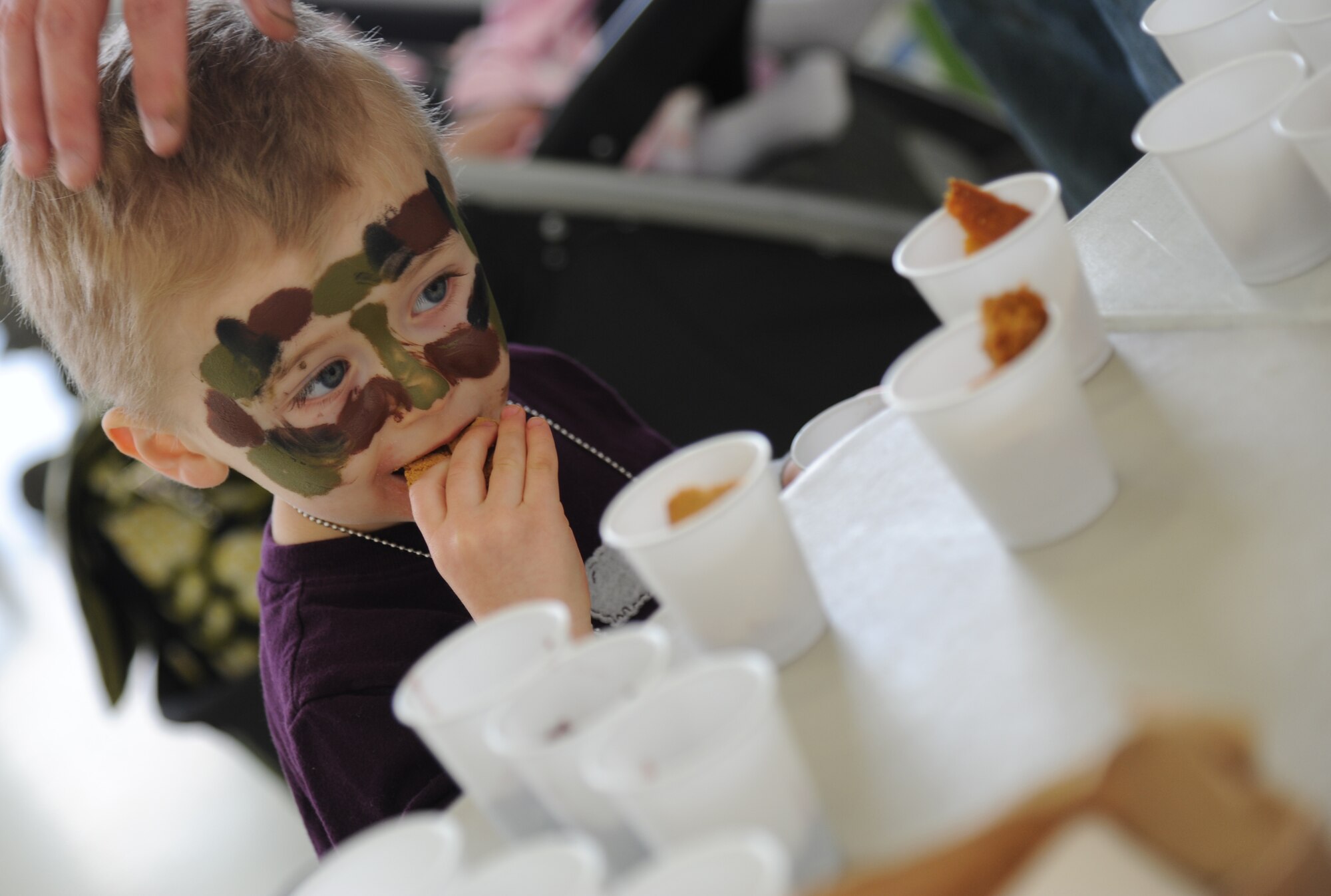 The son of 1st Lt. Brian Smith, 335th Training Squadron, eats a cookie from a meals-ready-to-eat package during Operation Hero March 8, 2014, at Keesler Air Force Base, Miss. The event was designed to help children better understand what happens when their parents deploy.  (U.S. Air Force photo by Kemberly Groue)