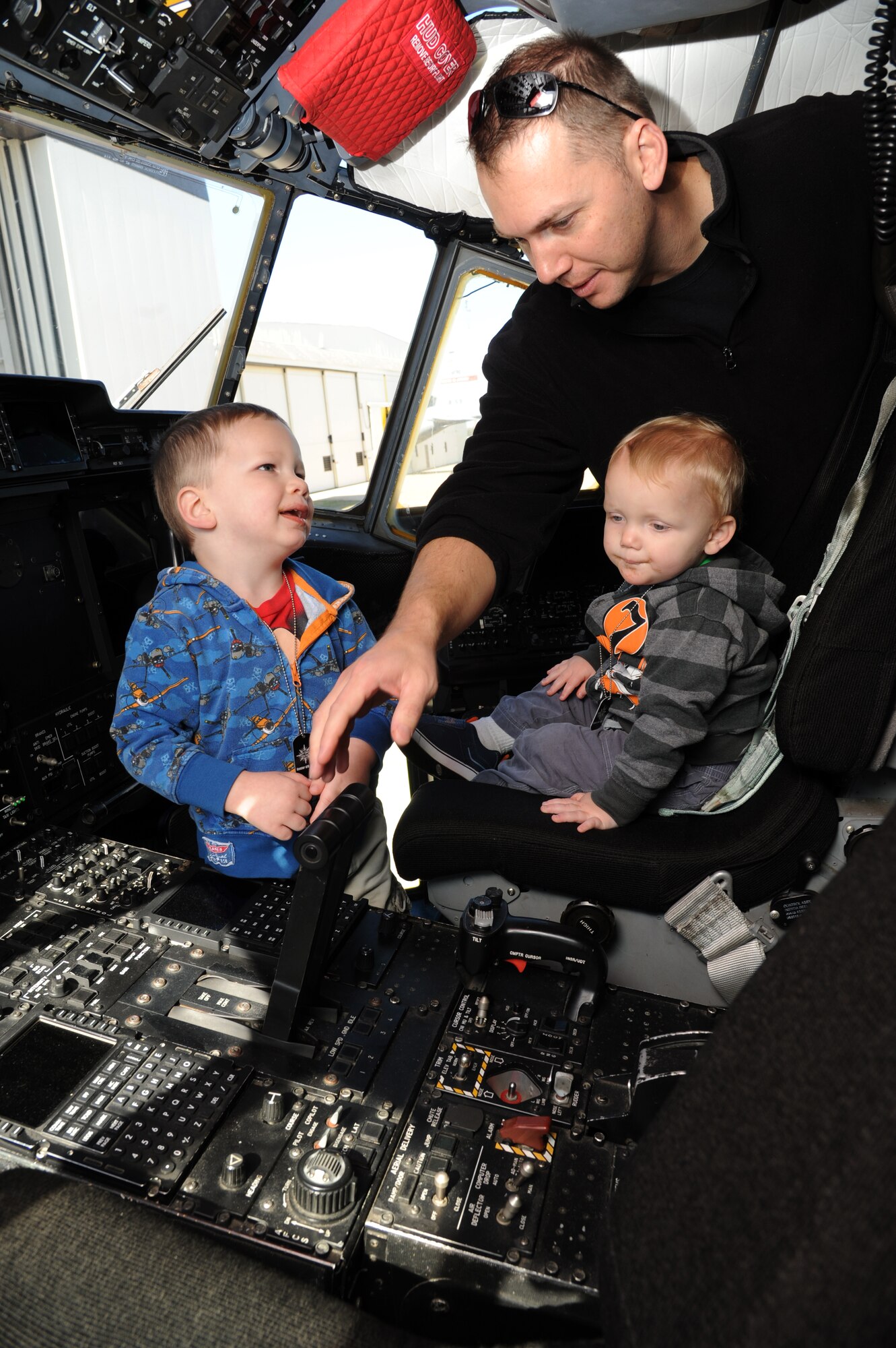 The husband and children of Maj. Gretchen Dues, 53rd Weather Reconnaissance Squadron, inspect the cockpit of a WC130J aircraft during Operation Hero March 8, 2014, at Keesler Air Force Base, Miss.  The event was designed to help children better understand what happens when their parents deploy.  (U.S. Air Force photo by Kemberly Groue)