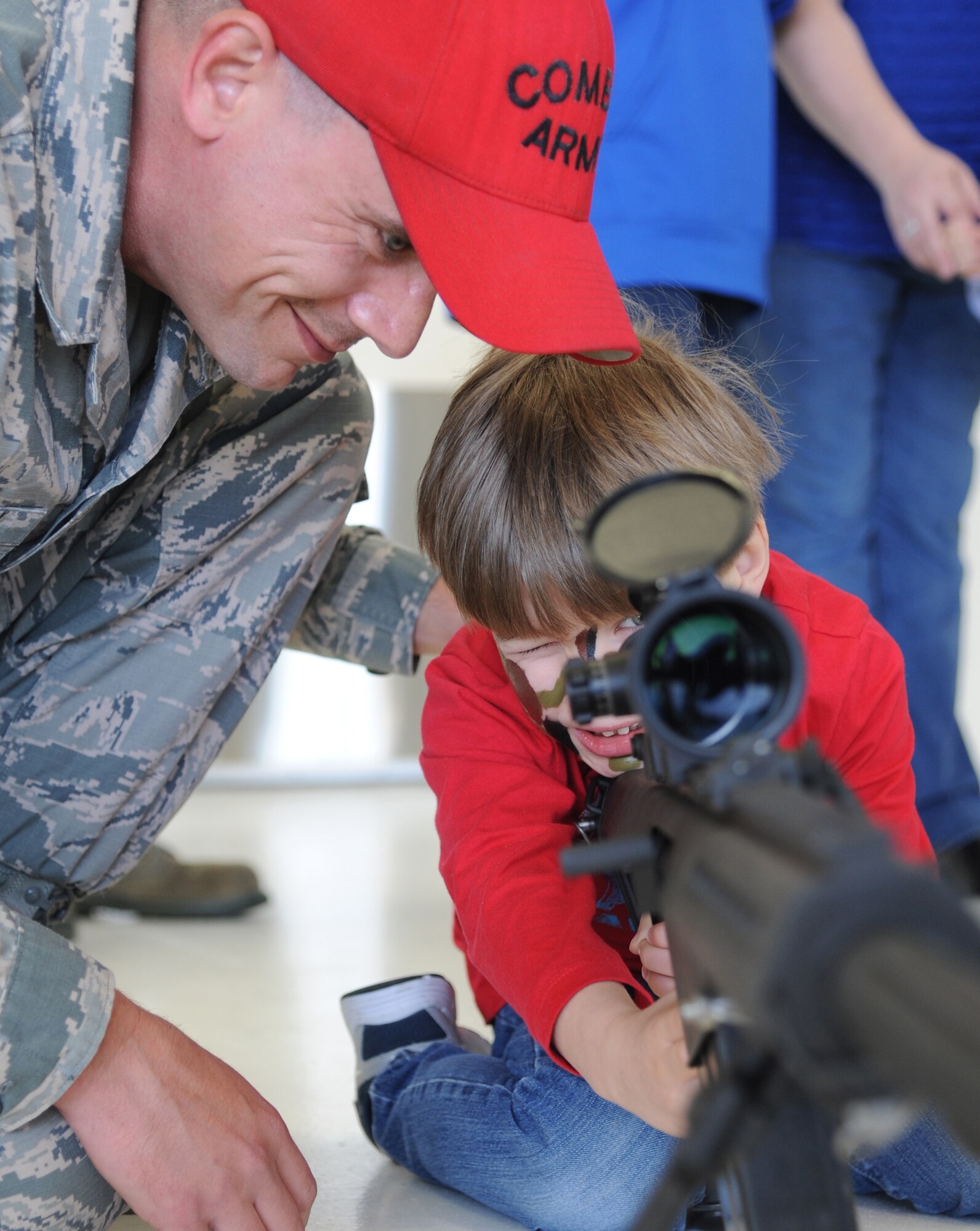 Tech. Sgt. Johnathan Johnson, 81st Security Forces Squadron, helps the son of Jay Mooney, 333rd Training Squadron,  look through the scope of an M-107 .50 caliber weapon during Operation Hero March 8, 2014, at Keesler Air Force Base, Miss.  The event was designed to help children better understand what happens when their parents deploy.  (U.S. Air Force photo by Kemberly Groue)