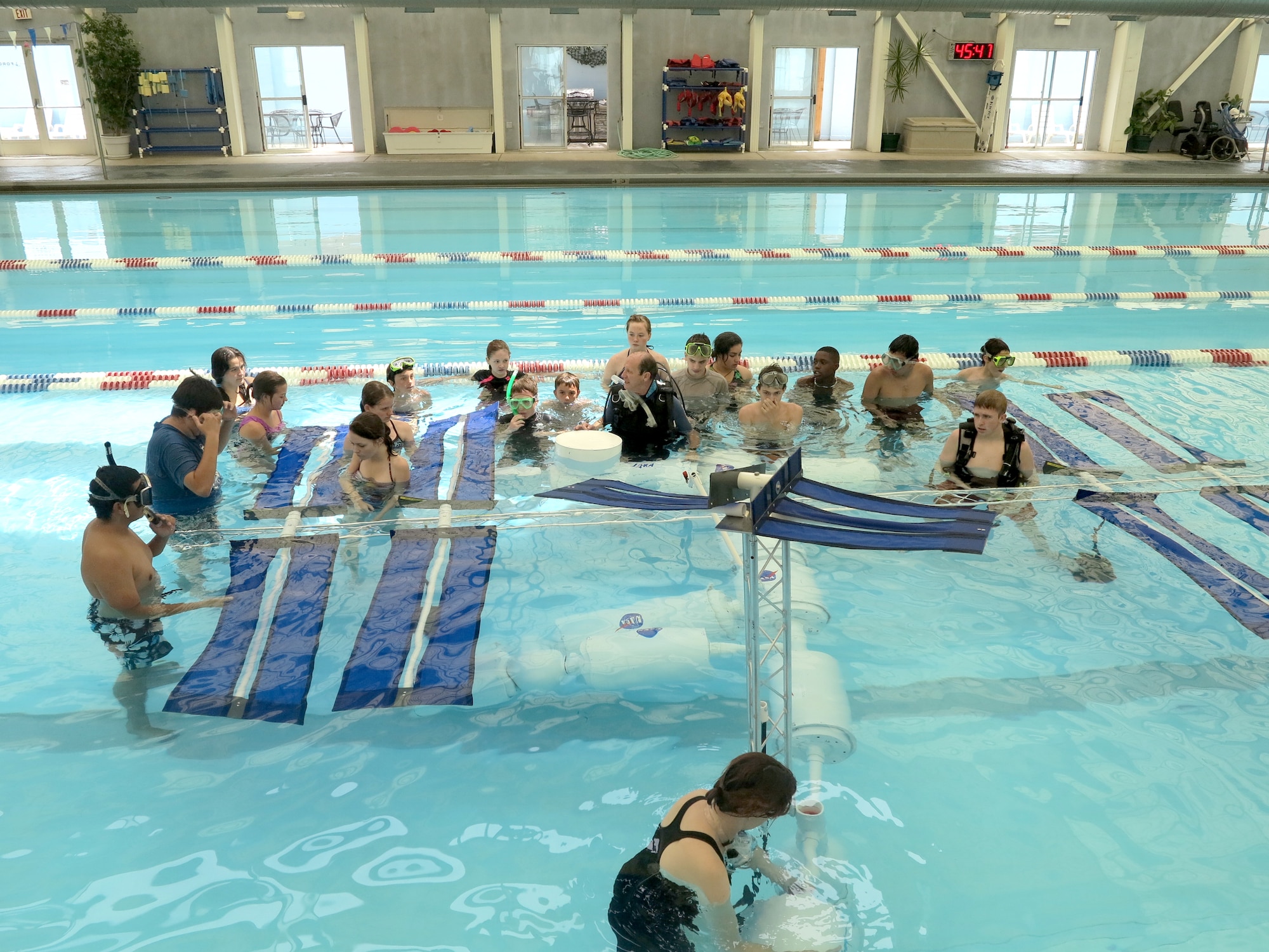 Students at AFRL’s La Luz Academy summer camp build an International Space Station model in swimming pool at Kirtland Air Force Base in Albuquerque, New Mexico. The students built the 22-foot model in water to simulate the microgravity conditions found in outer space. (Photo by Stephen Burke)