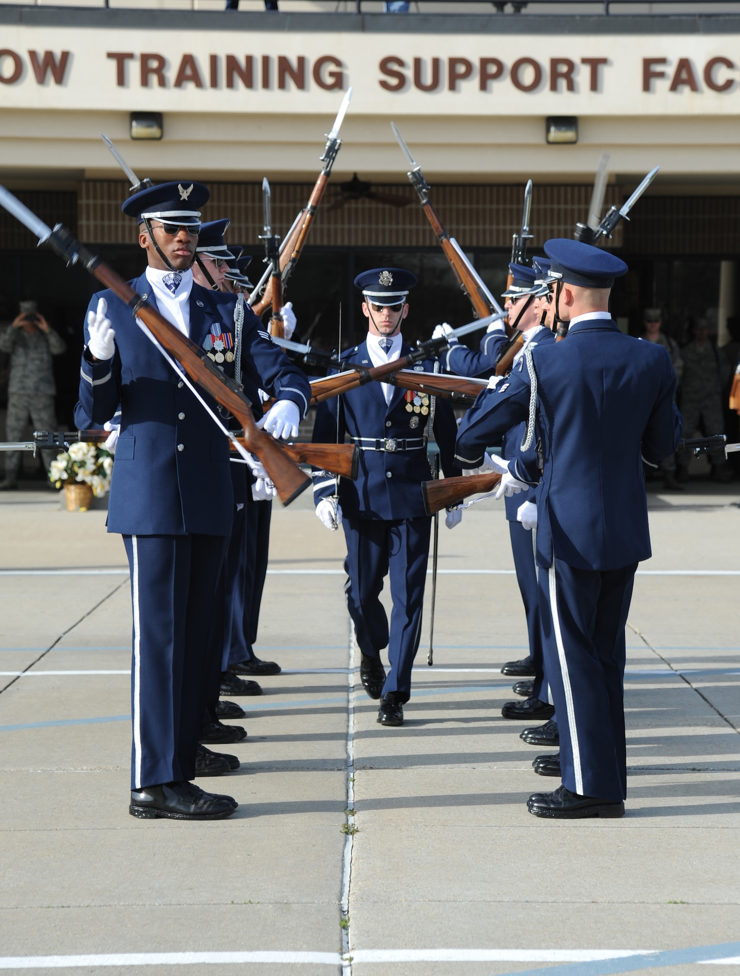 First Lt. Alan Morford, U.S. Air Force Honor Guard Drill Team flight commander, walks through two lines of drill team members as they spin their rifles during a performance on the drill pad behind the Levitow Training Support Facility March 7, 2014, at Keesler Air Force Base, Miss.  The routine was developed here during the past month and will be used for the next year. (U.S. Air Force photo by Kemberly Groue)