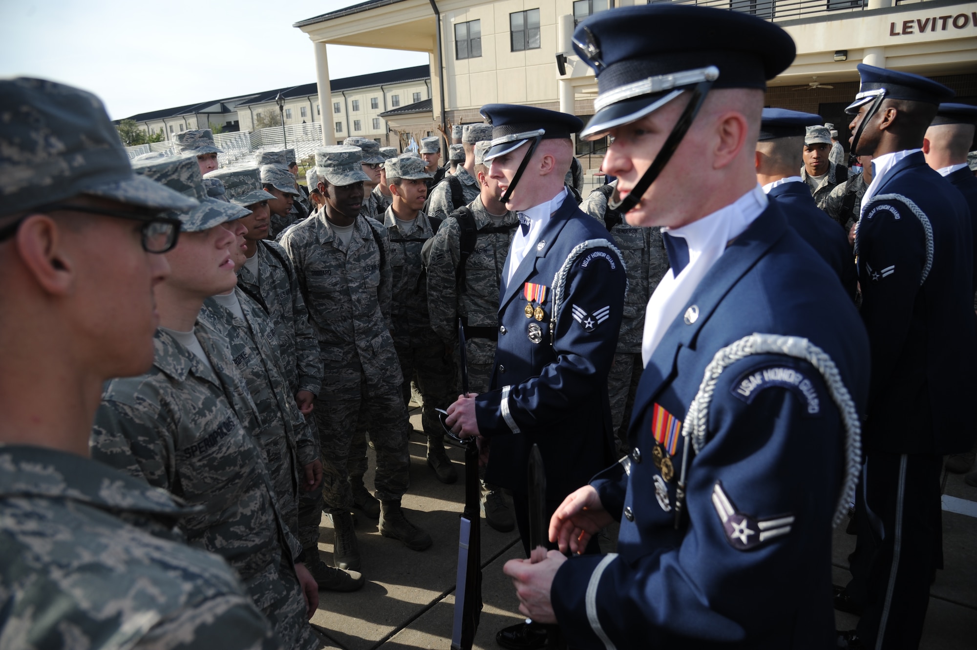 Senior Airman Alexander Wilson and Airman 1st Class Tucker Harrell, members of the U.S. Air Force Honor Guard Drill Team, speak to technical training students following a performance on the drill pad behind the Levitow Training Support Facility March 7, 2014, at Keesler Air Force Base, Miss.  The routine was developed here during the past month and will be used for the next year. (U.S. Air Force photo by Kemberly Groue)