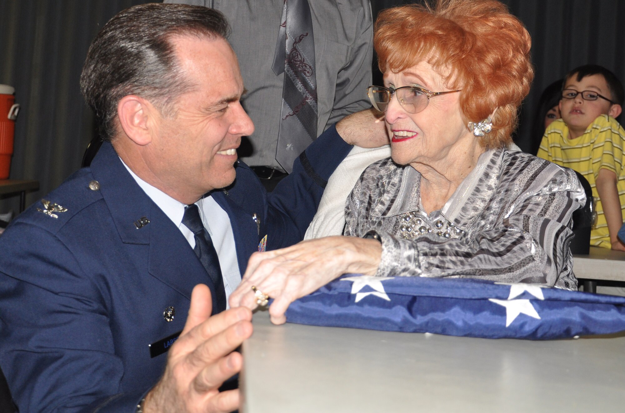 Col. Mark S. Larson, Commander of the 931st Air Refueling Group, presents a flag to Ginny Webb of Wichita in honor of the memory of her brother, Ravon Thomas, a Silver Star recipient, at the Joseph H. Herndon II VFW, American Legion Post in Derby, Kan. March 10. (Air Force photo by Master Sgt. Brannen Parrish)