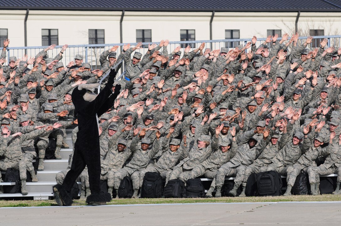 Airmen in the 335th Training Squadron cheer with their mascot bull prior to a performance by the U.S. Air Force Honor Guard Drill Team March 7, 2014, at Keesler Air Force Base, Miss.  The drill team unveiled the new routine they developed here during the past month and will use this routine for the next year. (U.S. Air Force photo by Kemberly Groue)