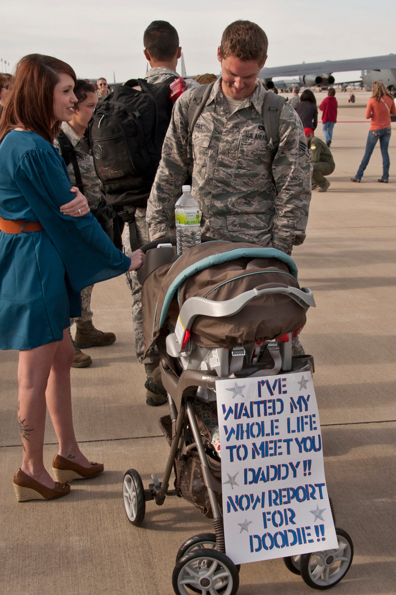 A U.S. Air Force Airman greets a new member of his family at Barksdale Air Force Base, La., March 7, 2014. He was one of 280 Airmen who returned home from a six-month deployment to Andersen Air Force Base, Guam, in support of the Air Force's Continuous Bomber Presence in the South China Sea. (U.S. Air Force photo by Master Sgt. Jeff Walston/Released)  