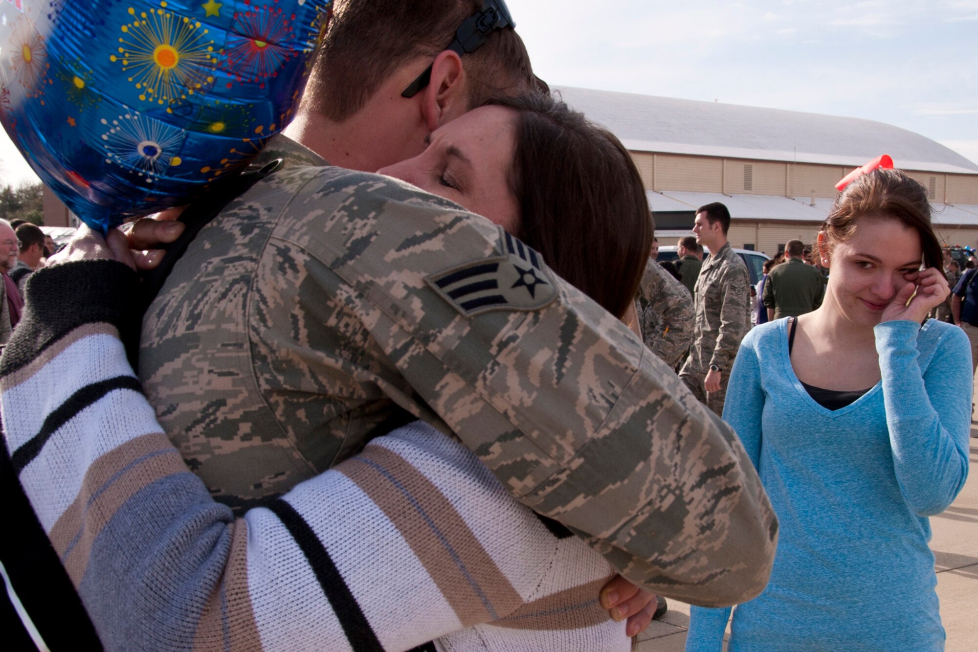 U.S. Air Force Senior Airman Ryan Tackett, an electronic warfare systems mechanic assigned to the 707th Maintenance Squadron, receives a welcome hug from his mother, Darlene Tackett as his sister waits her turn at Barksdale Air Force Base, La., March 7, 2014. Tackett was one of 280 Barksdale Airmen and one of 18 from the 307th Bomb Wing to return home from a six-month deployment to Andersen Air Force Base, Guam. (U.S. Air Force photo by Master Sgt. Jeff Walston/Released)  