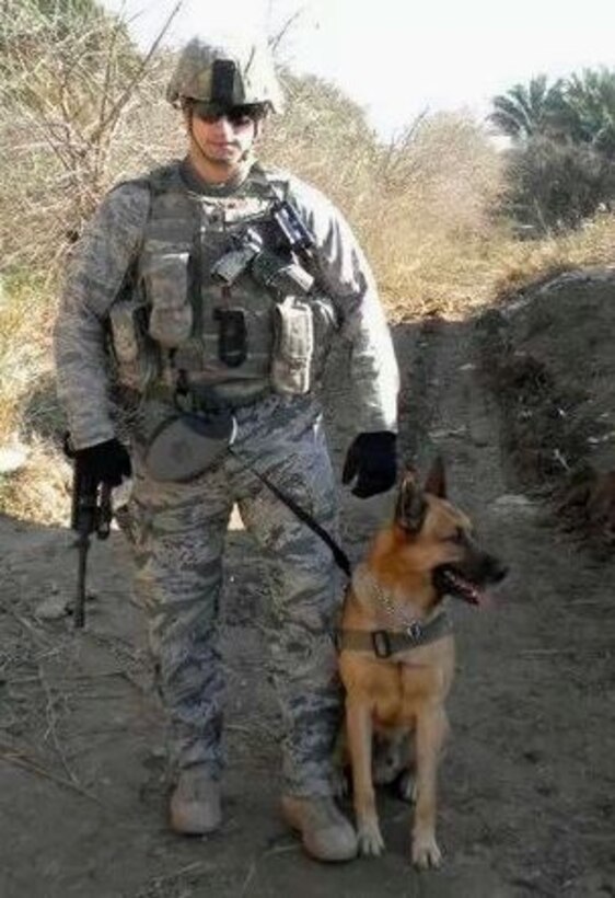 Tech. Sgt. Aaron DeMarte stands with Arco, retired Military Working Dog,
while deployed to the Middle East. (U.S. Air Force courtesy photo)
