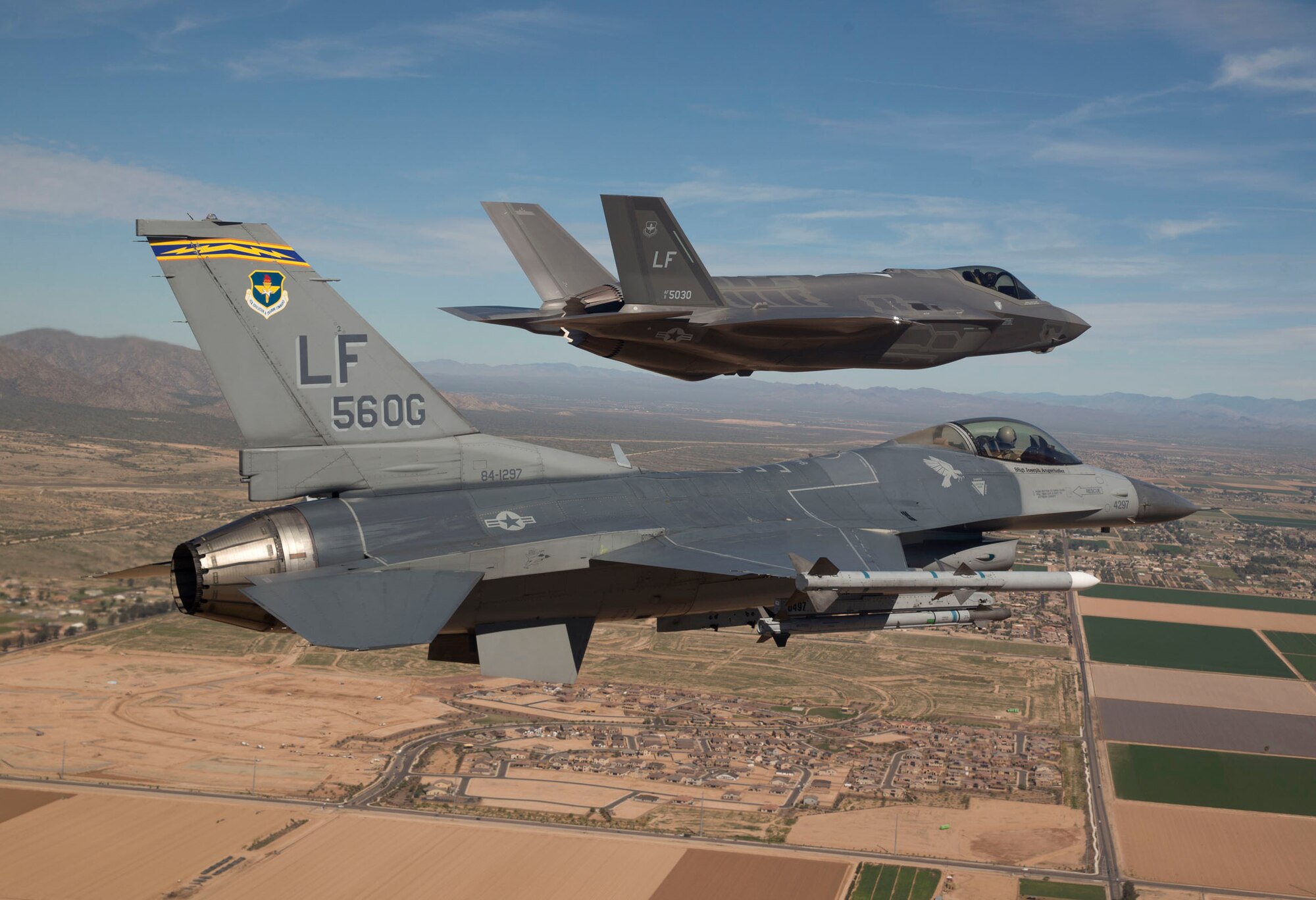 Maj. Justin Robinson, 61st Fighter Squadron assistant director of operations, flies the 56th Operations Group flagship F-16 as he escorts Luke’s first F-35 to the base for its arrival on March 10. The F-35 was flown by Col. Roderick Cregier, an F-35 test pilot stationed at Edwards AFB, Calif. The jet is the first of 144 F-35s that will eventually be assigned to Luke. (U.S. Air Force photo/Jim Hazeltine) 