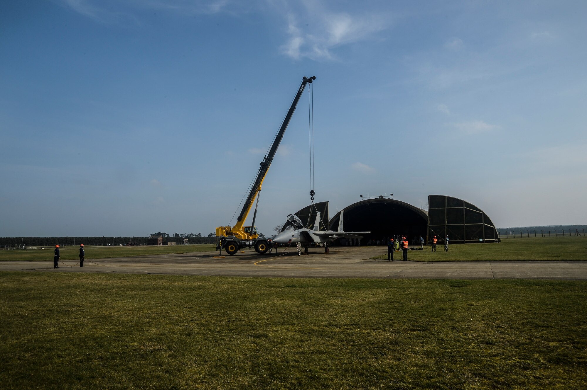 An F-15B jet is lifted during Certification Crash Damaged Disabled Aircraft Recovery training on the flight line at Royal Air Force Lakenheath, England, March 8, 2014. The training exercise was an annual joint event between RAFs Mildenhall and Lakenheath which helped familiarize and requalify Airmen on aircraft lifting procedures. (U.S. Air Force photo by Airman 1st Class Nigel Sandridge/Released)