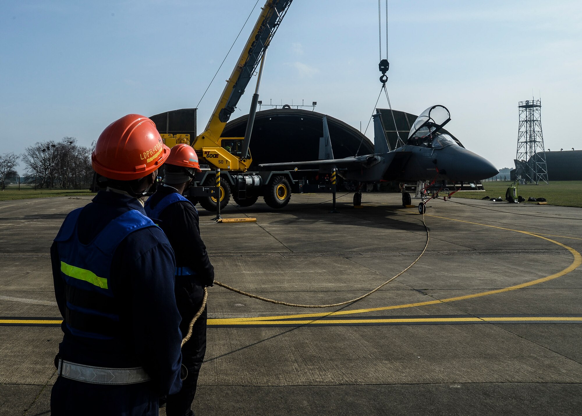Airmen of the 48th Maintenance Squadron use ropes to stabilize an F-15B jet while lifted during Certification Crash Damaged Disabled Aircraft Recovery training on the flightline at Royal Air Force Lakenheath, England, March 8, 2014. The training exercise was an annual joint event between RAFs Mildenhall and Lakenheath which helped familiarize and requalify Airmen on aircraft lifting procedures. (U.S. Air Force photo by Airman 1st Class Nigel Sandridge/Released)