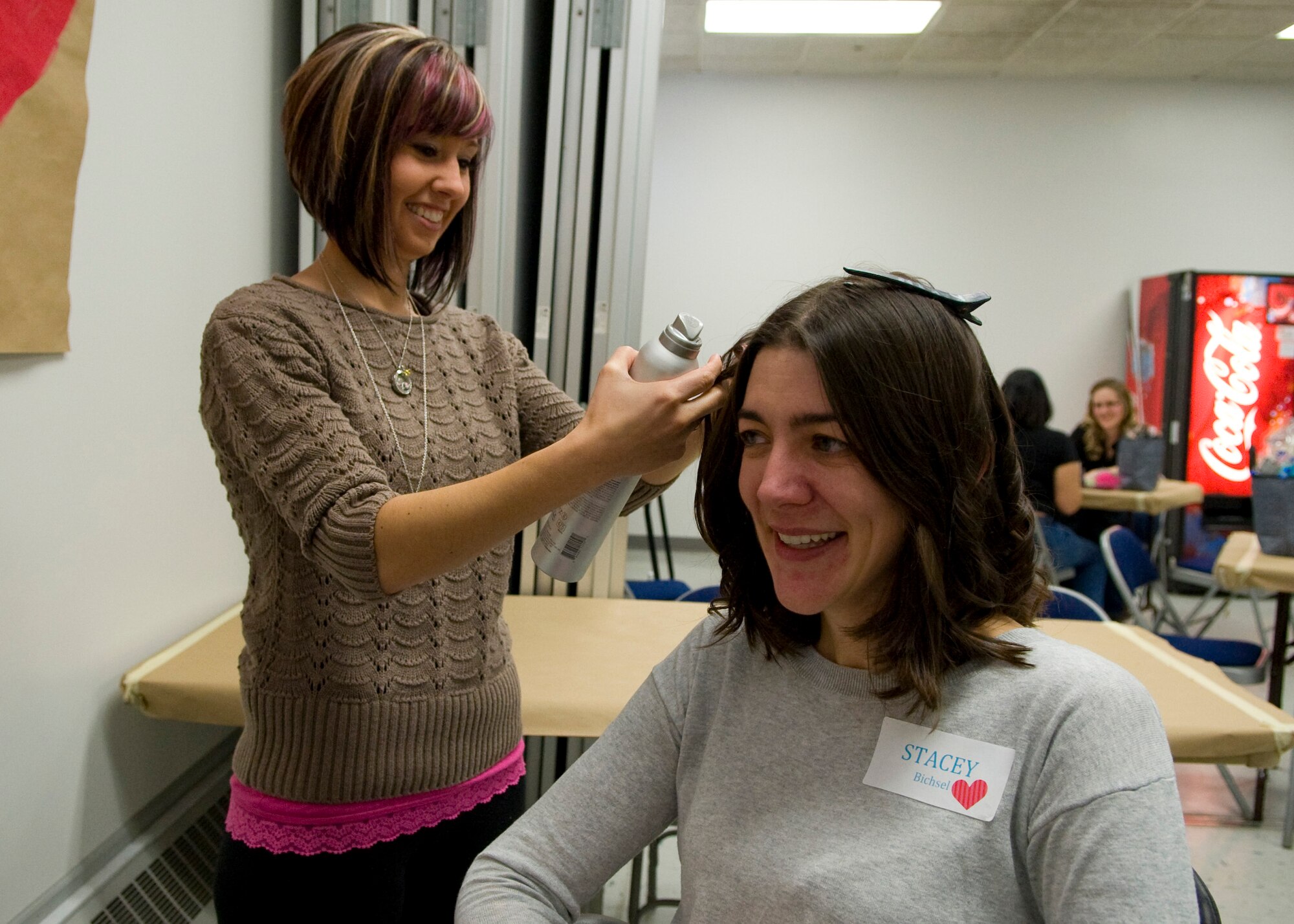 Jessica McClendon, wife of Staff Sgt. Andrew McClendon, 436th Security Forces Squadron unit deployment manager, styles the hair of Stacey Bichsel, wife of Capt. Todd Bichsel, 512th Civil Engineer Squadron operations flight commander, at a spa day for the spouses of deployed Team Dover Airmen March 7, 2014, at Chapel Two on Dover Air Force Base, Del. The spouses were pampered during the event hosted by the Dover Key Spouses organization with getting their hair styled, nails done, massages, meditation sessions, make-up demonstrations, jewelry, and food. (U.S. Air Force photo/Airman 1st Class Zachary Cacicia)
