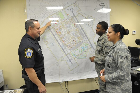 Richard Coon (left), 902nd Security Forces Squadron police supervisor, points out a map location to Senior Airmen Frederick Randolph and Sierra Contreras Feb. 27 at Joint Base San Antonio-Randolph.( U.S. Air Force photo by Joel Martinez) 