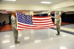 Air Force Senior Airmen Antonio Montalvo, left, Air Education and Training Command, and Jessica Aulenbacher, Air Force Personnel Center, both members of the Joint Base San Antonio Honor Guard, practice folding the flag Feb. 25 at JBSA-Randolph.(U.S. Air Force photo by Joel Martinez)