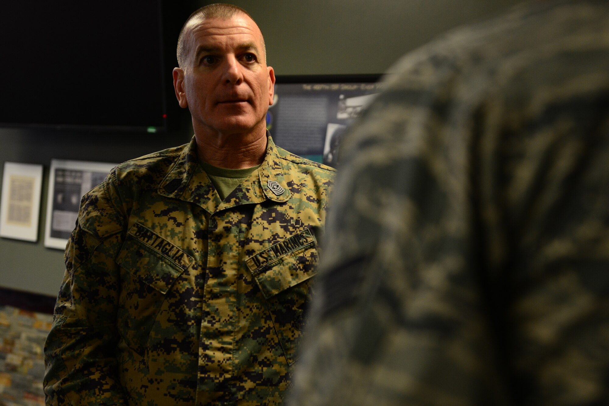 U.S. Marine Corps Sgt. Maj. Bryan Battaglia, Senior Enlisted Advisor to the Chairman of the Joint Chiefs of Staff, speaks with the Airmen Committed to Excellence president from the 497th Intelligence Reconnaissance Wing at Langley Air Force Base, Va., March 7, 2014. Battagila learned of the different programs the 497th has after a tour of the building. (U.S. Air Force photo by Airman 1st Class Kimberly Nagle/Released)(Photo cropped to emphasize the subject)