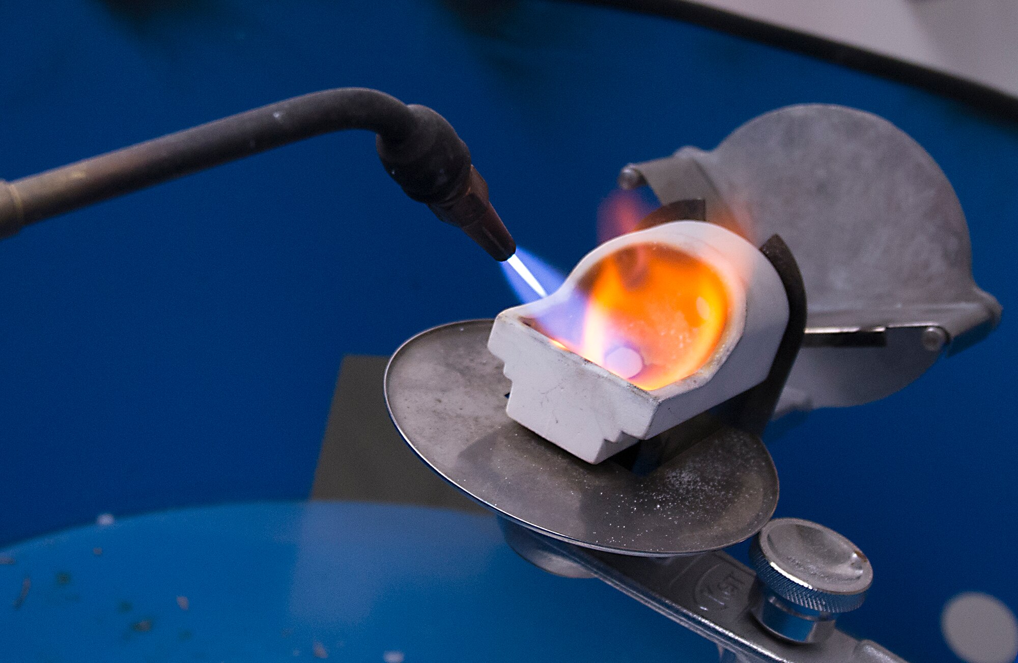 U.S. Air Force Tech. Sgt. Matthew Fitzgerald, 23d Aerospace Medicine Squadron NCO in charge of dental laboratory, uses a torch to melt down gold for a crown at Moody Air Force Base, Ga., March 6, 2014. The dental clinic recently celebrated Dental Assistants Recognition Week, a tradition dating back to 1978. (U.S. Air Force photo by Senior Airman Tiffany M. Grigg/Released) 