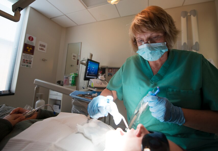 Cindy Allen, 23d Aerospace Medicine Squadron dental hygienist, performs a dental cleaning on U.S. Air Force Staff Sgt. Amber Mullis, 23d Maintenance Operations Flight scheduler, at Moody Air Force Base, Ga., March 6, 2014. The dental clinic recently celebrated Dental Assistants Recognition Week, a week designated to recognizing the dedication, professionalism and contribution of dental assistants worldwide. (U.S. Air Force photo by Senior Airman Tiffany M. Grigg/Released) 