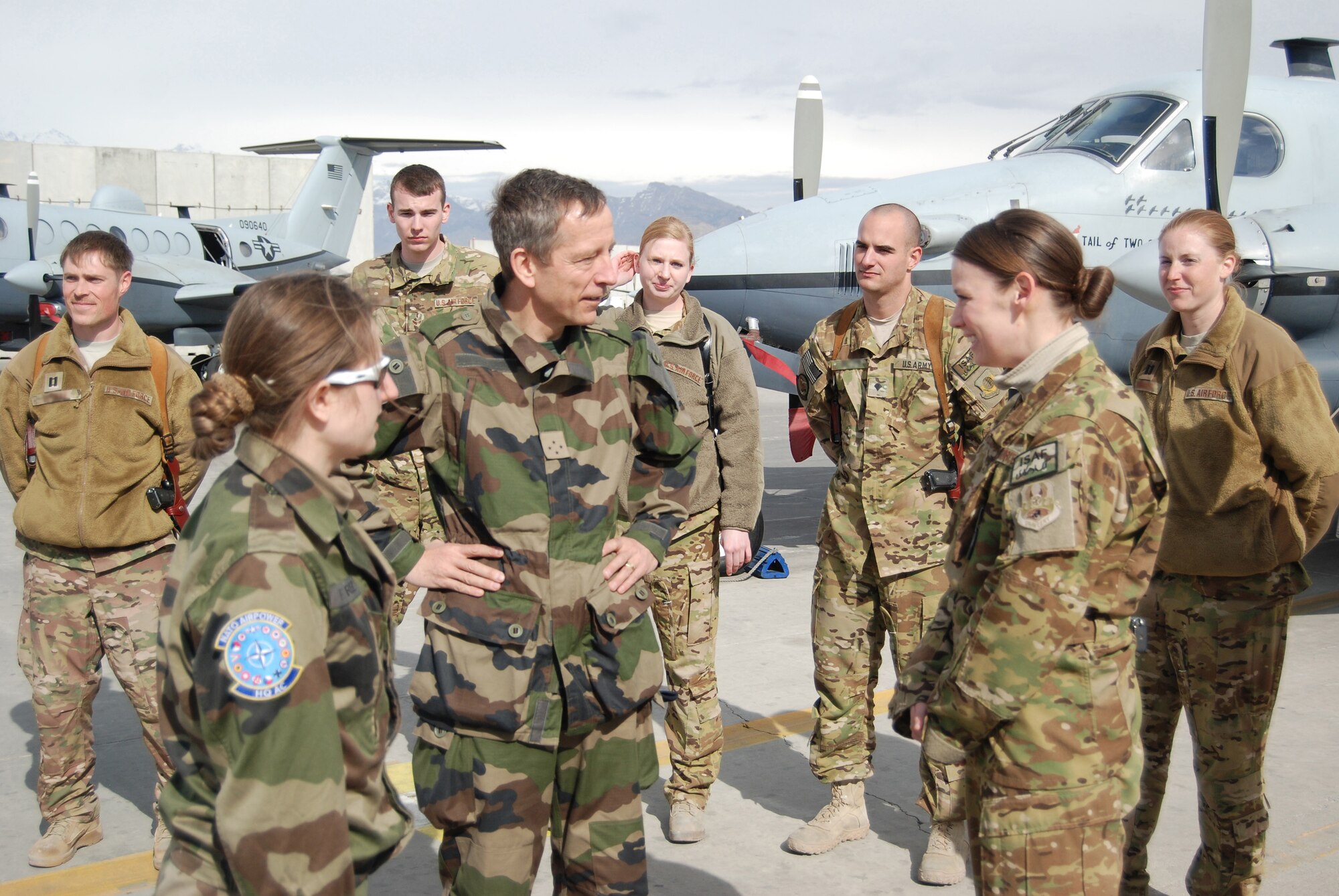 French Lt. Gen. Dominique de Longvilliers, NATO Allied Air Command deputy commander, talks to an MC-12W crew member during a visit to Bagram Airfield, March 10, 2014. Longvilliers was traveling with U.S. Air Force Gen. Frank Gorenc, NATO Allied Air Command and U.S. Air Forces in Europe-Air Forces Africa commander, who had lunch with company grade officers, received a tour of the MC-12W squadron and met with 455th Air Expeditionary Wing leadership. (U.S. Air Force photo by Capt. Brian Wagner/Released) (Some last names blurred on photo for operational security.)